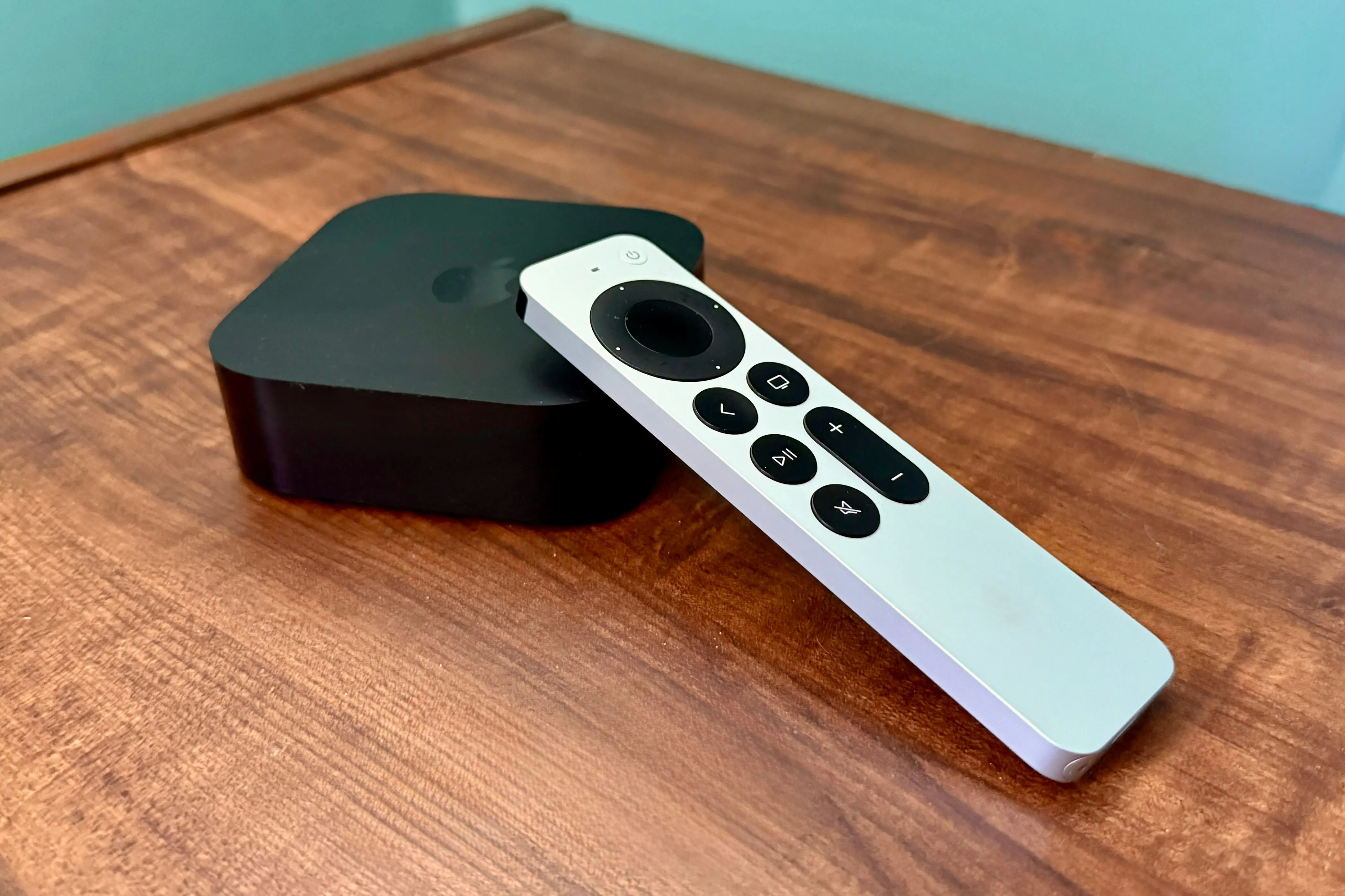 Apple TV 4K và điều khiển từ xa trên bàn gỗ