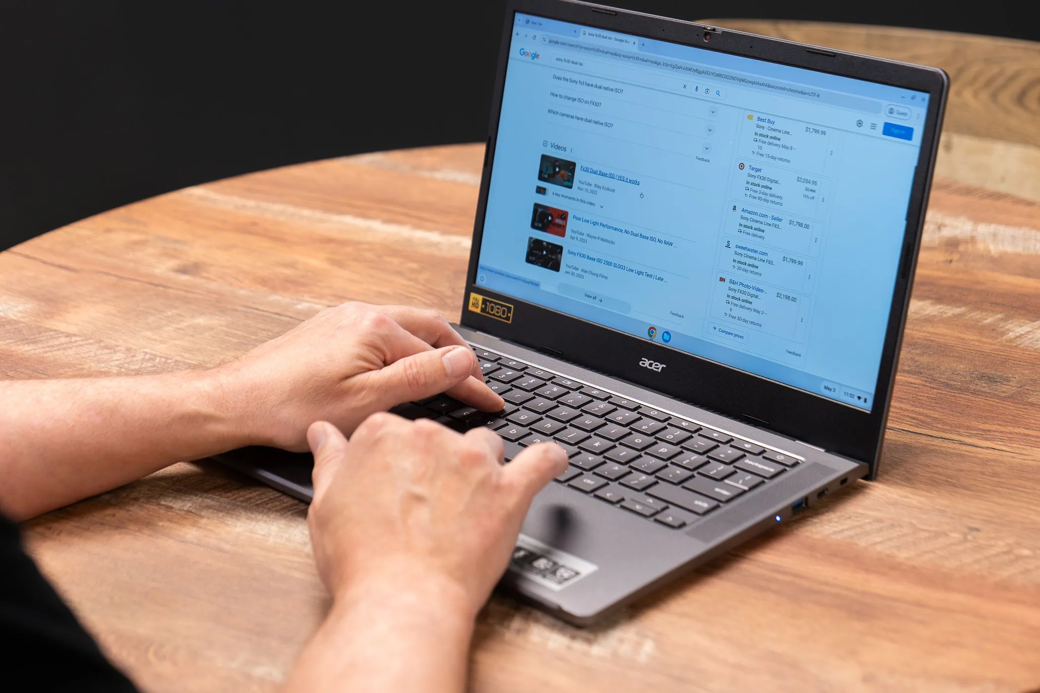 Bàn tay đang gõ phím trên Acer Chromebook đặt trên bàn làm việc