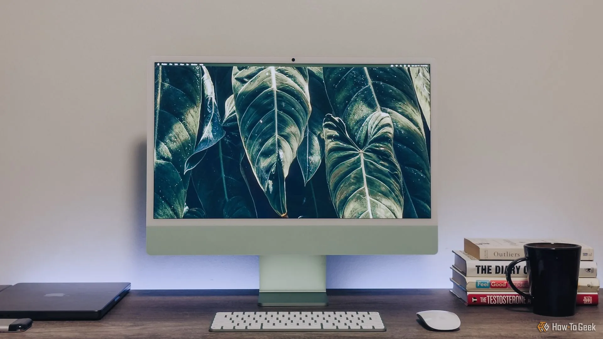 Bộ máy tính iMac Apple Silicon màu xanh lá đầy đủ trên bàn làm việc, thể hiện sự trở lại của màu sắc