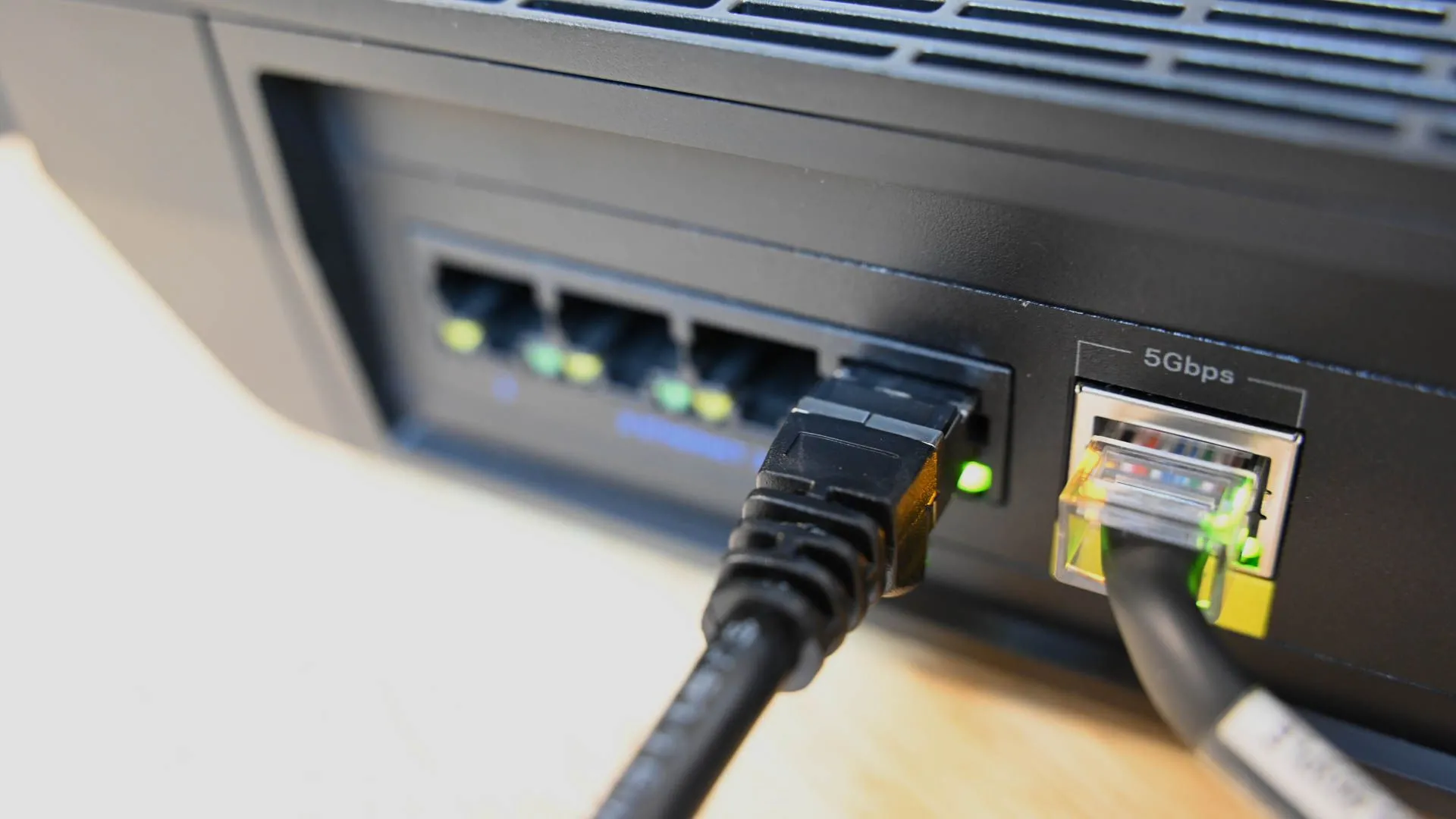 Cận cảnh cáp Ethernet cắm vào cổng mạng router, minh họa việc NAS sử dụng băng thông