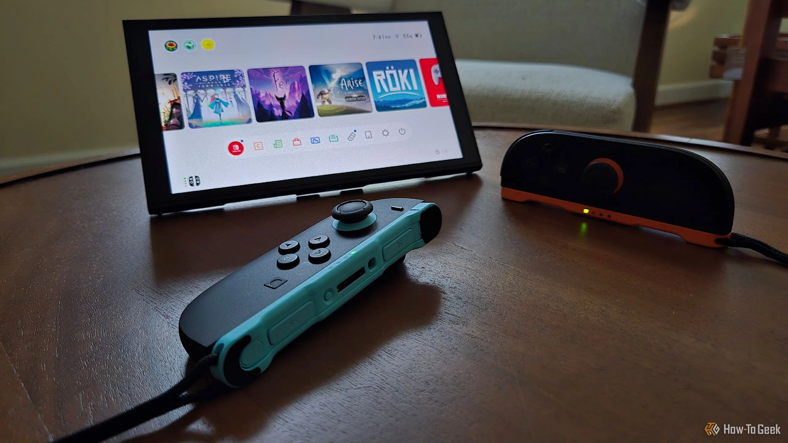 Cặp tay cầm Joy-Con 2 đặt trước một chiếc Switch 2 dựng đứng bằng chân đế tích hợp, với một tay cầm được dùng như chuột