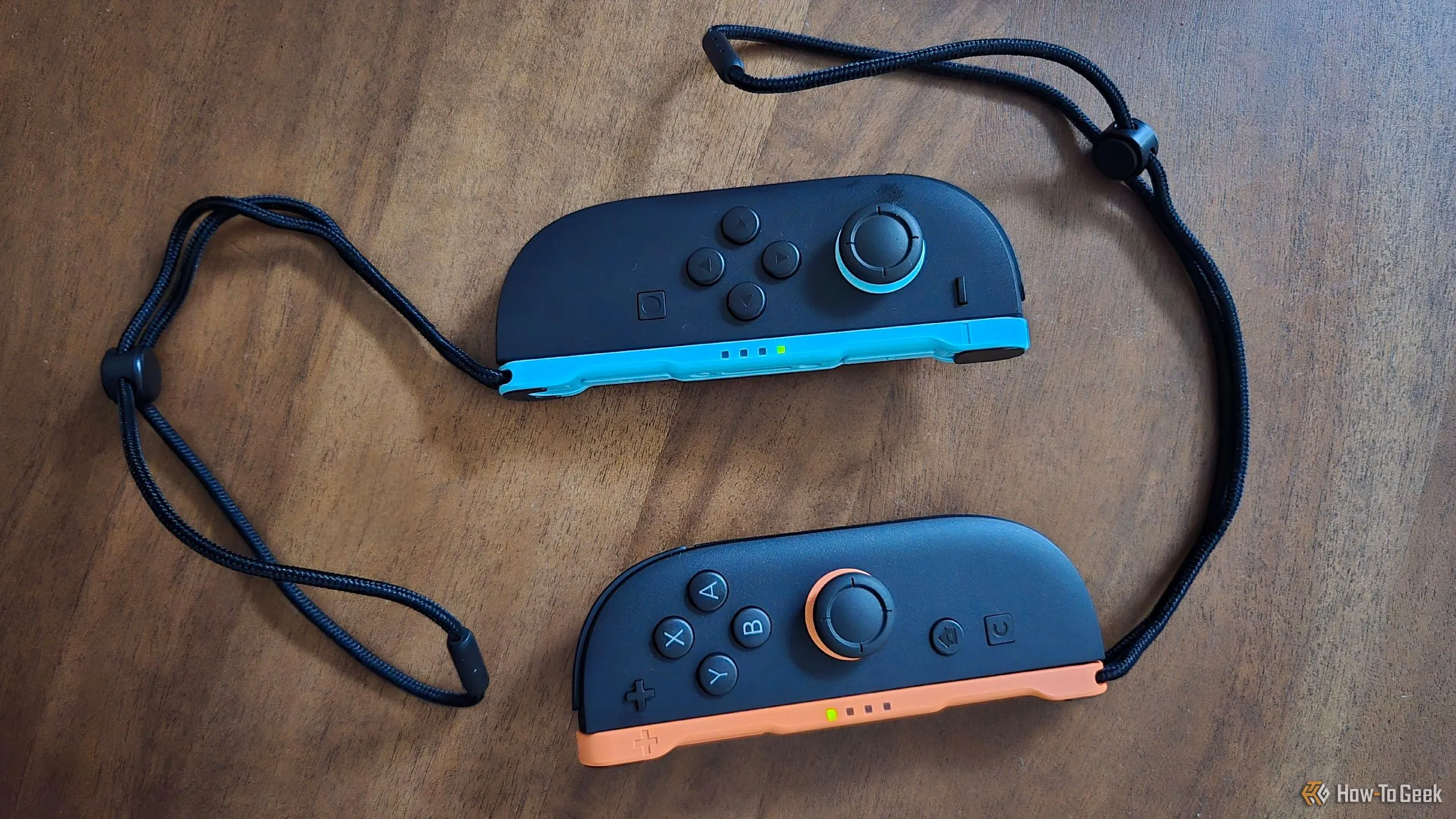 Cặp tay cầm Joy-Con 2 trên bàn, kèm dây đeo cổ tay