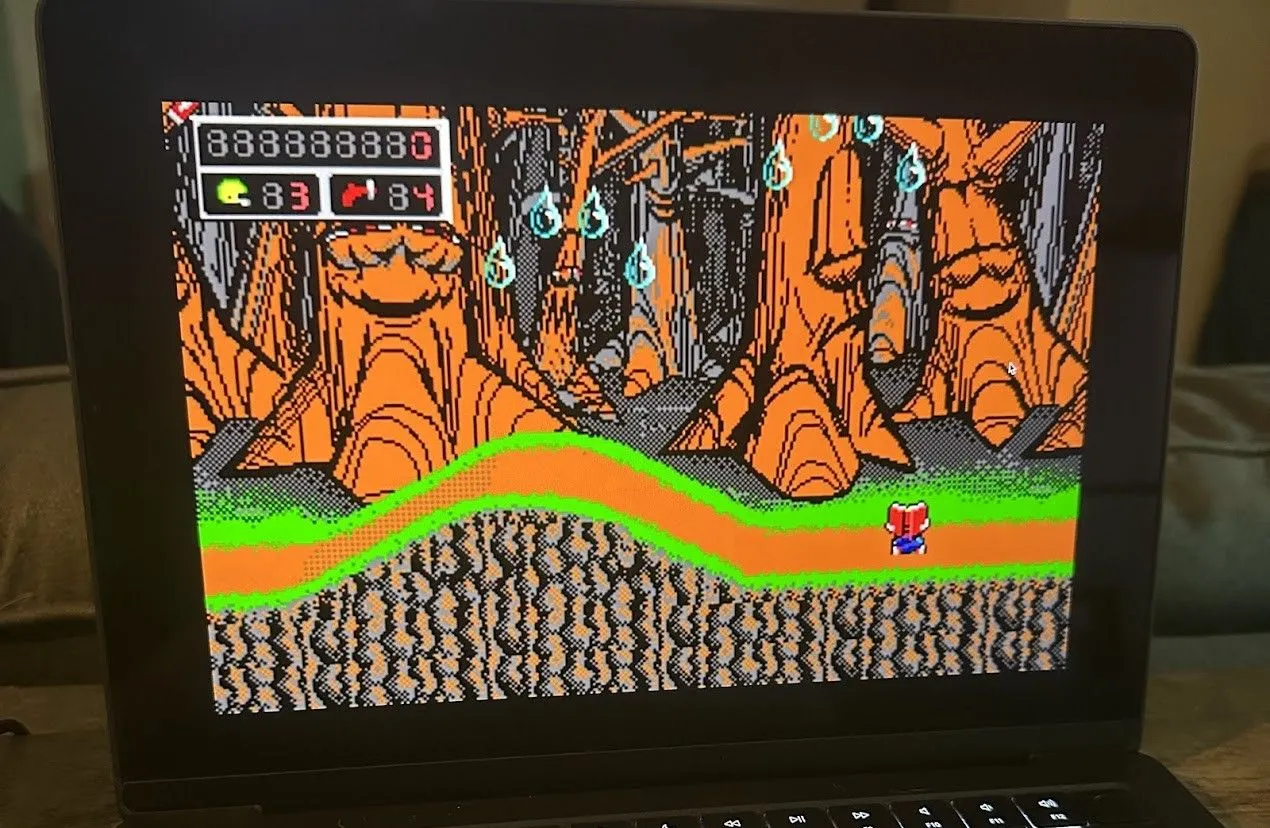 Commander Keen, game platformer cổ điển, đang được chơi trên MacBook Pro, hiển thị nhân vật chính trong môi trường 2D.