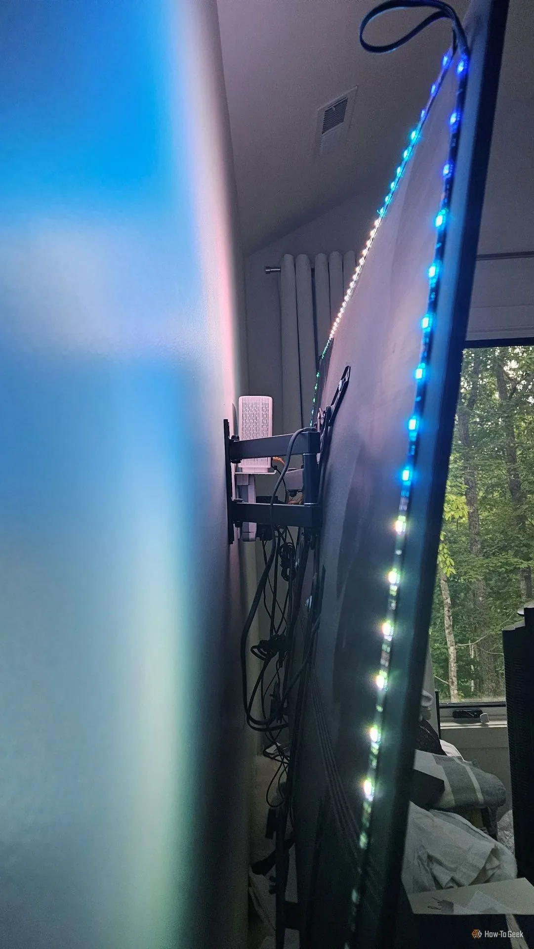 Dải đèn LED của WiZ HDMI Sync Box được gắn phía sau TV để tạo hiệu ứng ánh sáng nền.