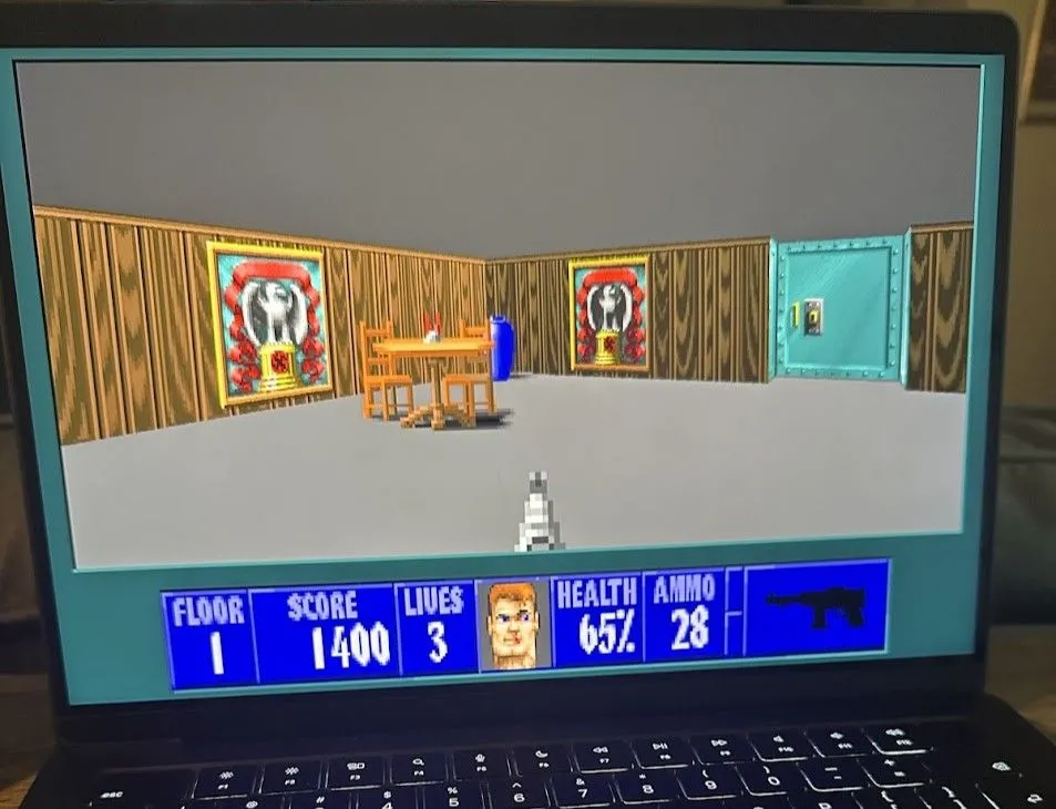 Game Wolfenstein 3D (Wolf3D) đang chạy trên MacBook Pro, thể hiện lối chơi bắn súng góc nhìn thứ nhất với đồ họa retro.