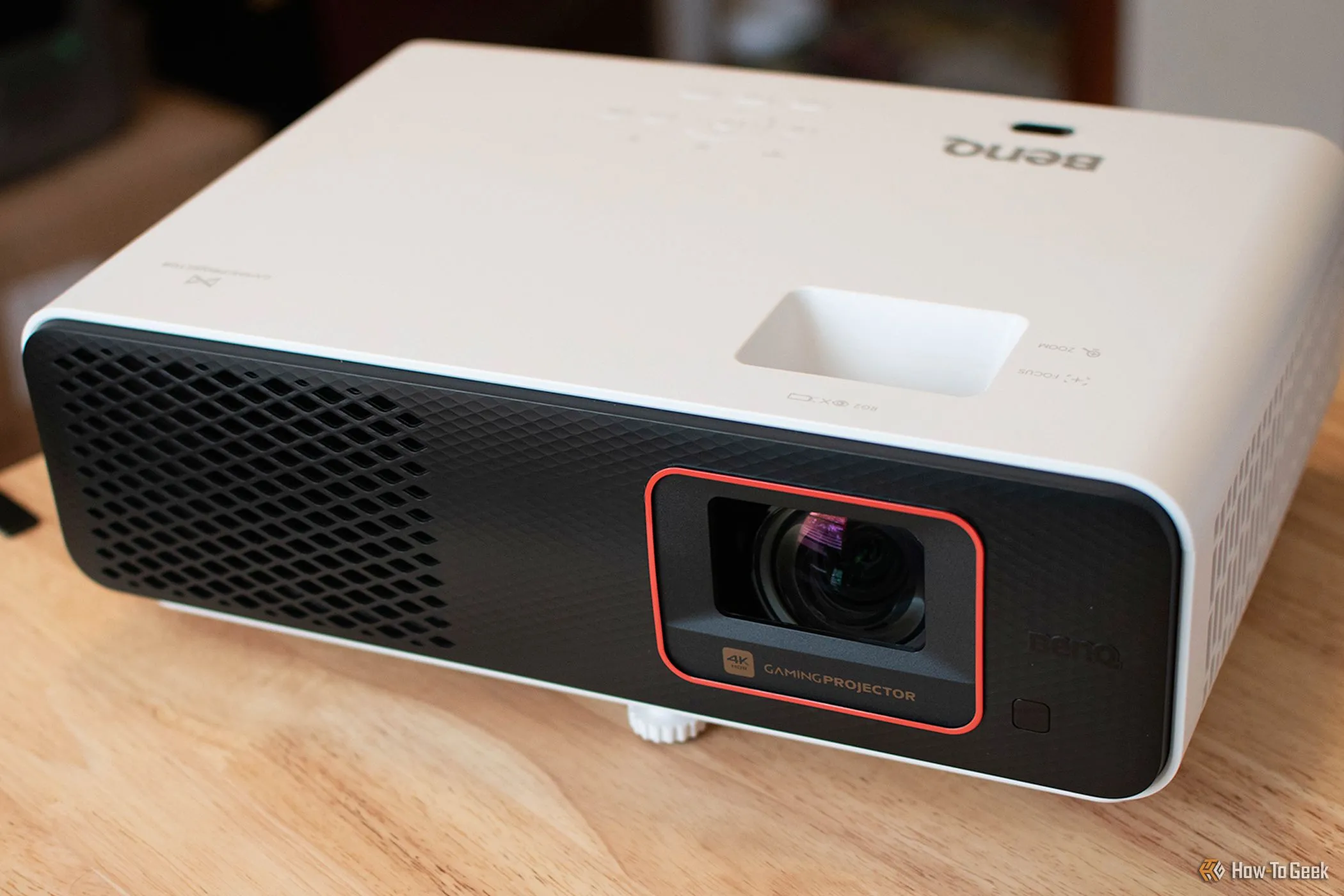 Máy chiếu chơi game chiếu gần BenQ X500i đặt trên bàn với màn hình lớn