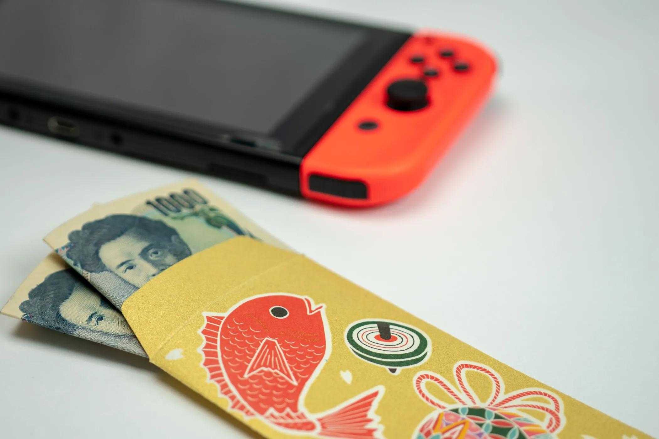 Máy chơi game Nintendo Switch và cọc tiền mặt biểu tượng cho chi phí