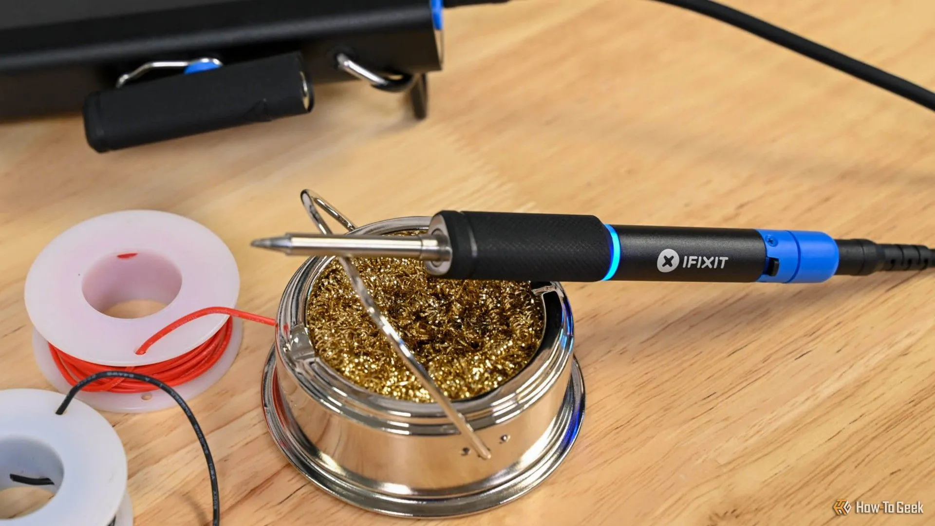 Mỏ hàn di động iFixit FixHub trên giá đỡ, minh họa công cụ chuyên dụng cần thiết để sửa chữa cổng USB-C PD trên bo mạch chủ laptop