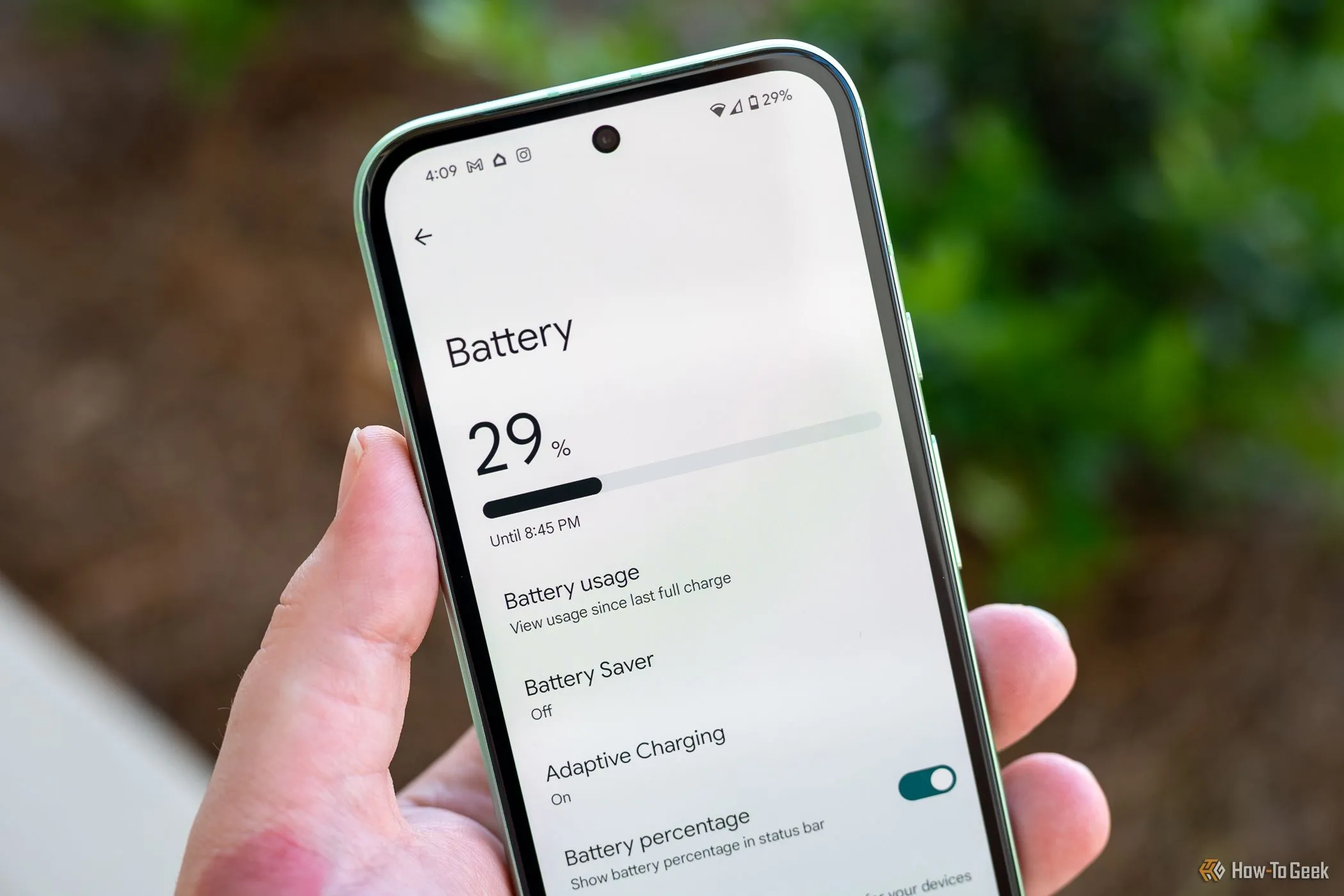 Một người đang cầm điện thoại Google Pixel 8a hiển thị menu cài đặt pin, minh họa cách kiểm tra và duy trì sức khỏe pin điện thoại để tối ưu giá bán.