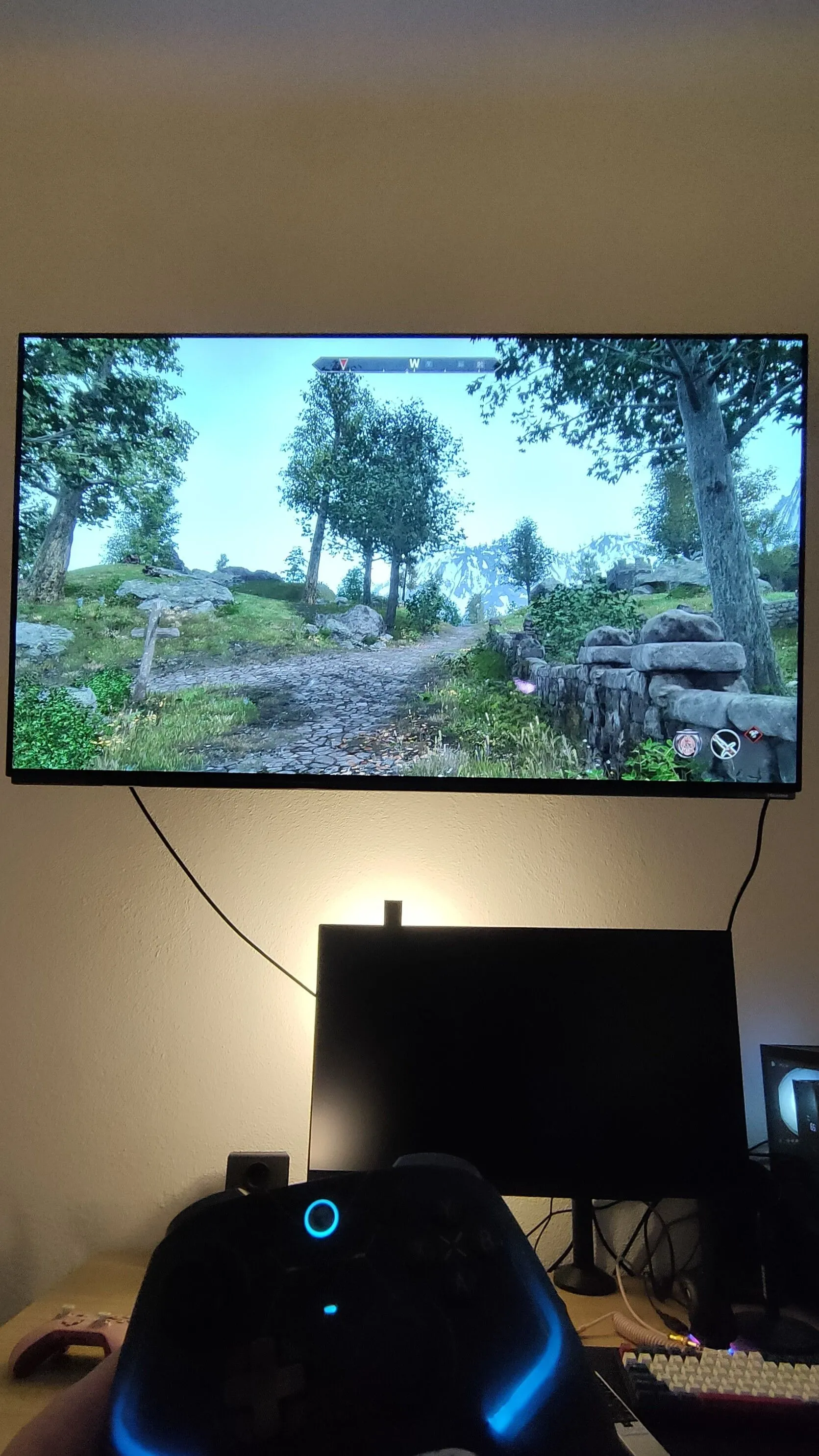 Một người đang chơi tựa game The Elder Scrolls IV: Oblivion Remastered trên màn hình TV OLED 4K lớn bằng bộ điều khiển, thể hiện sự thoải mái khi chơi game trên TV.