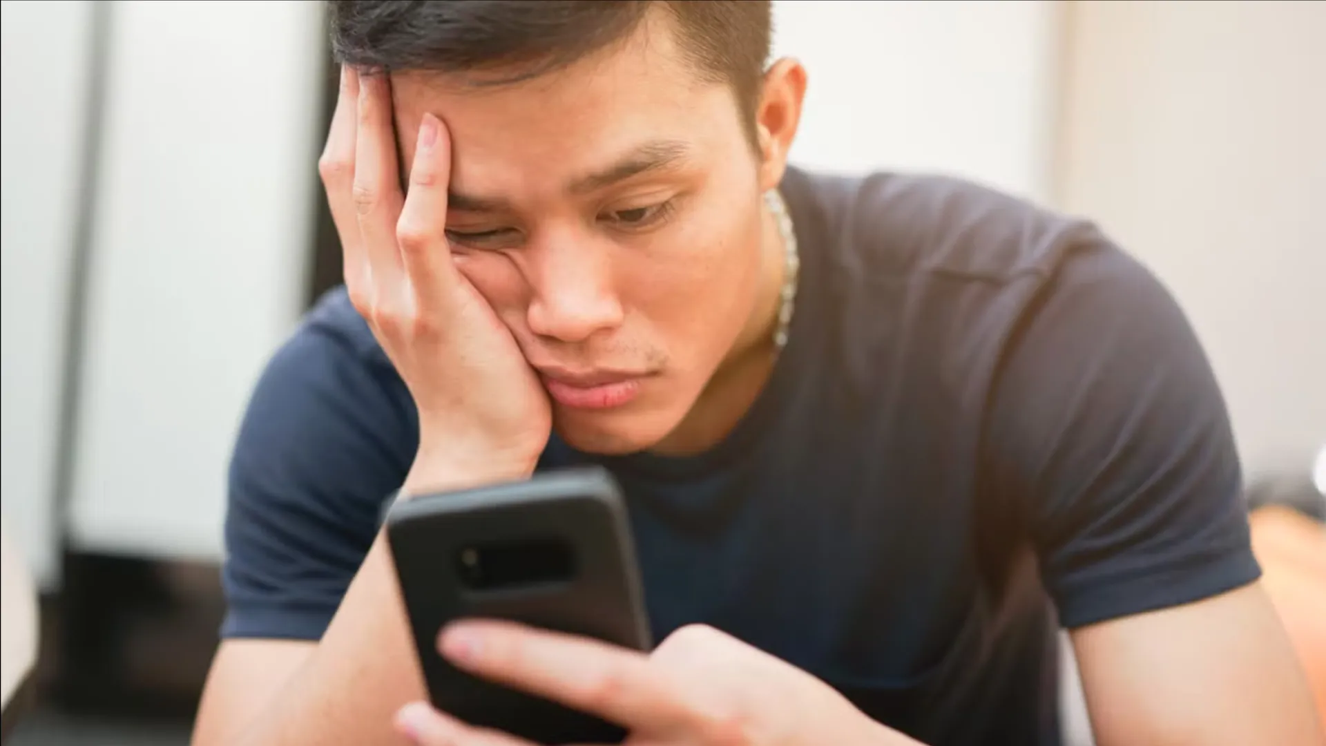 Một người lướt điện thoại với vẻ mặt chán nản, cần giải pháp chống lướt vô định