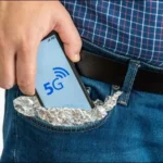 Người đàn ông bỏ smartphone bọc giấy bạc vào túi, minh họa quan ngại về sóng 5G.