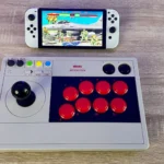 Tay cầm arcade 8BitDo chơi Street Fighter 2 trên Nintendo Switch OLED, minh họa kỹ năng né đòn và i-frame trong game đối kháng.