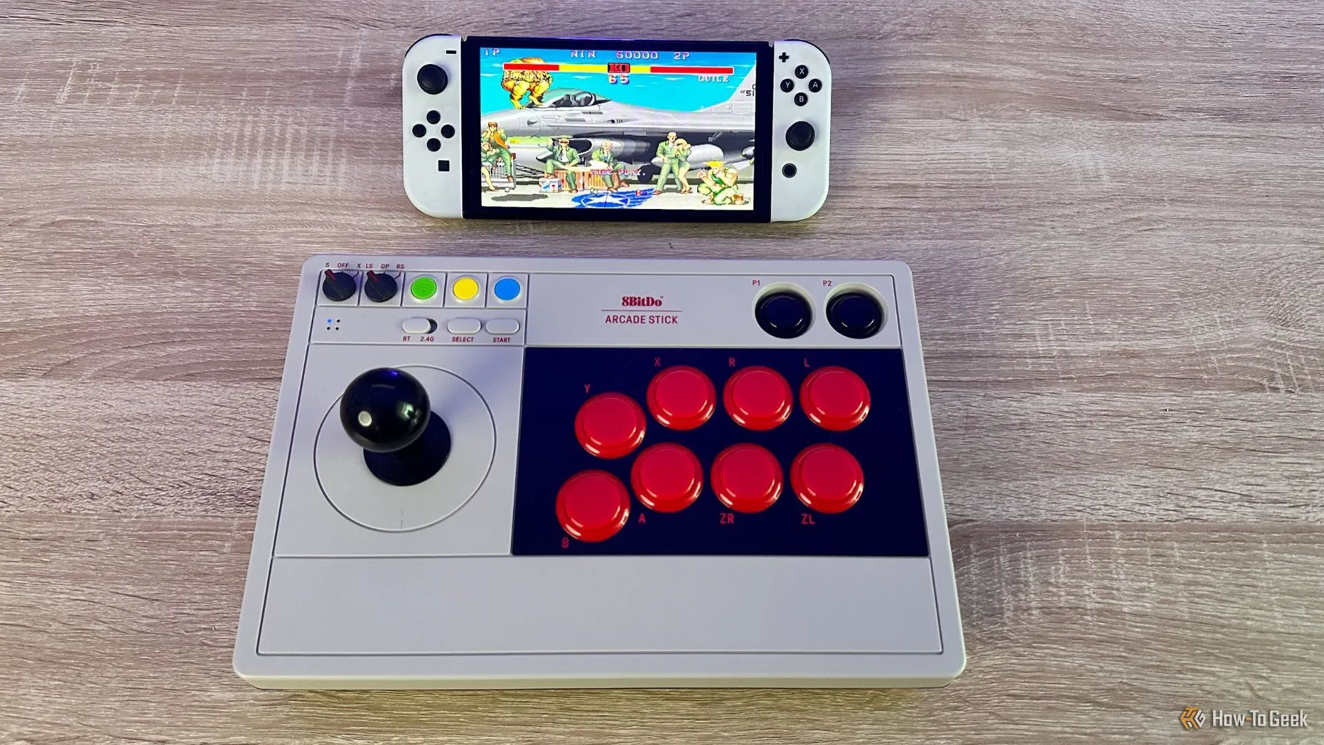 Tay cầm arcade 8BitDo chơi Street Fighter 2 trên Nintendo Switch OLED, minh họa kỹ năng né đòn và i-frame trong game đối kháng.