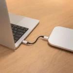Vỏ bọc SSD Satechi USB4 được cắm vào laptop trên bàn làm việc, minh họa tính di động và khả năng sử dụng thực tế của thiết bị lưu trữ tốc độ cao.