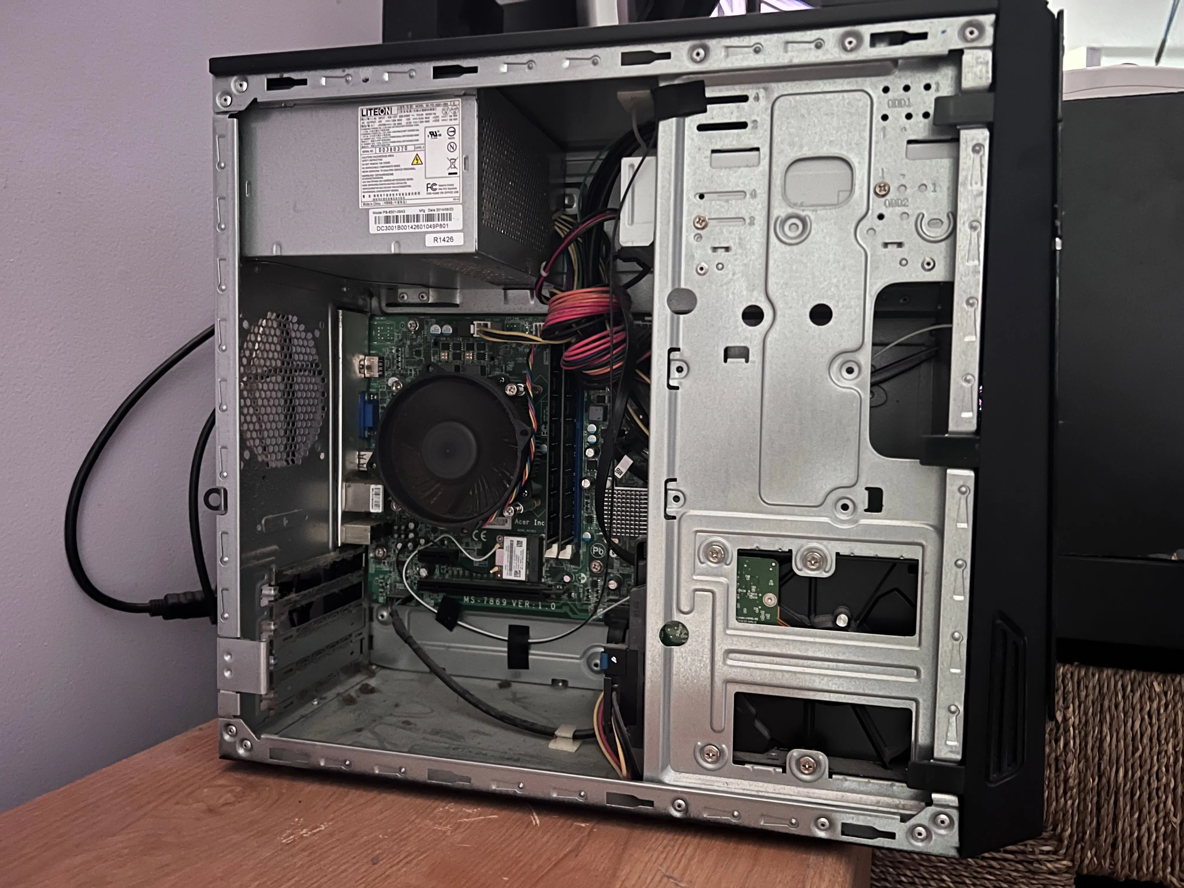 Bên trong case máy tính để bàn Acer đã tháo nắp bên, để lộ các linh kiện và khe cắm RAM trên mainboard.