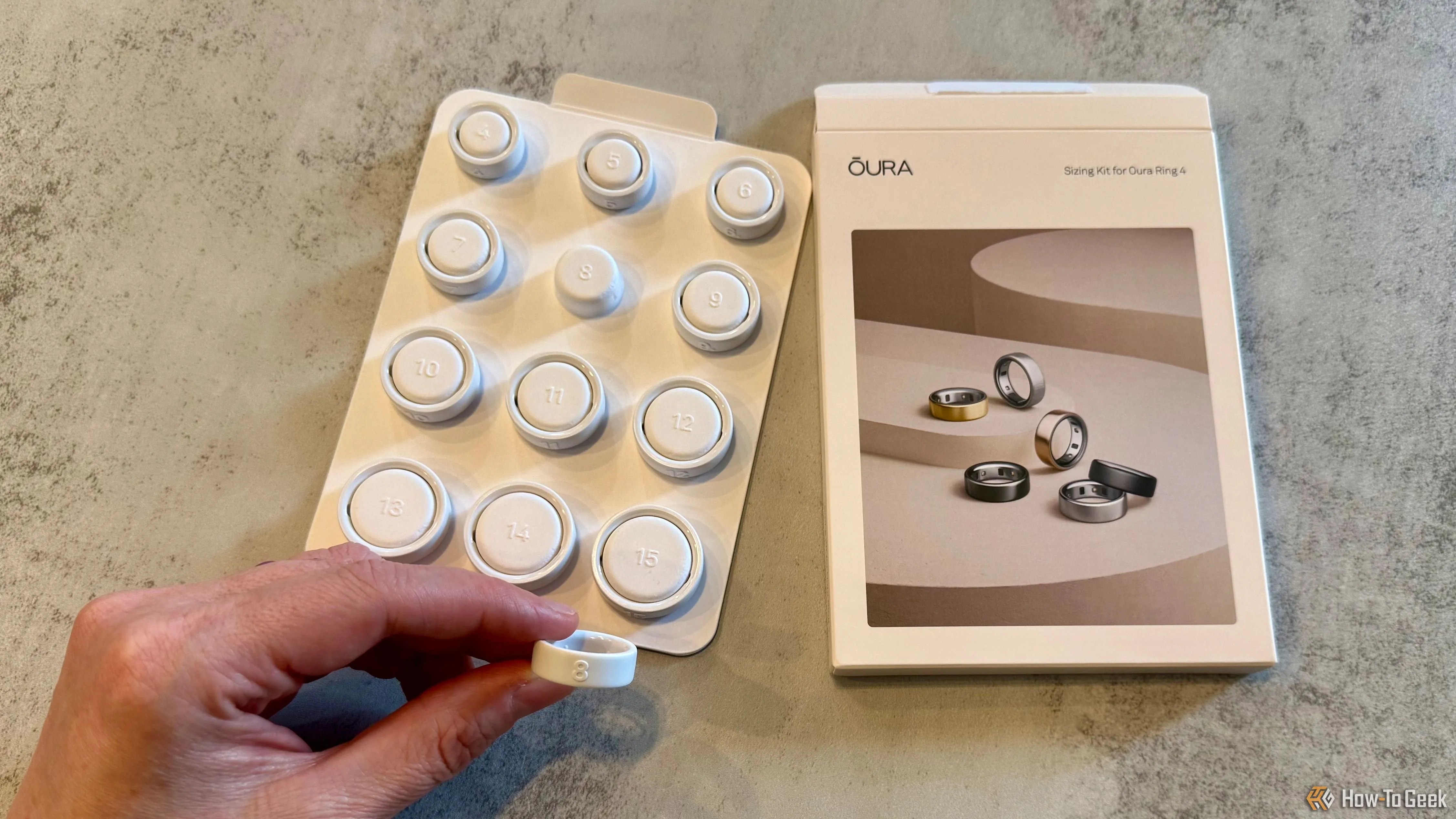 Bộ dụng cụ đo kích thước Oura Ring 4 với một chiếc nhẫn đo đang được cầm trên tay, giúp chọn size phù hợp trước khi mua nhẫn.