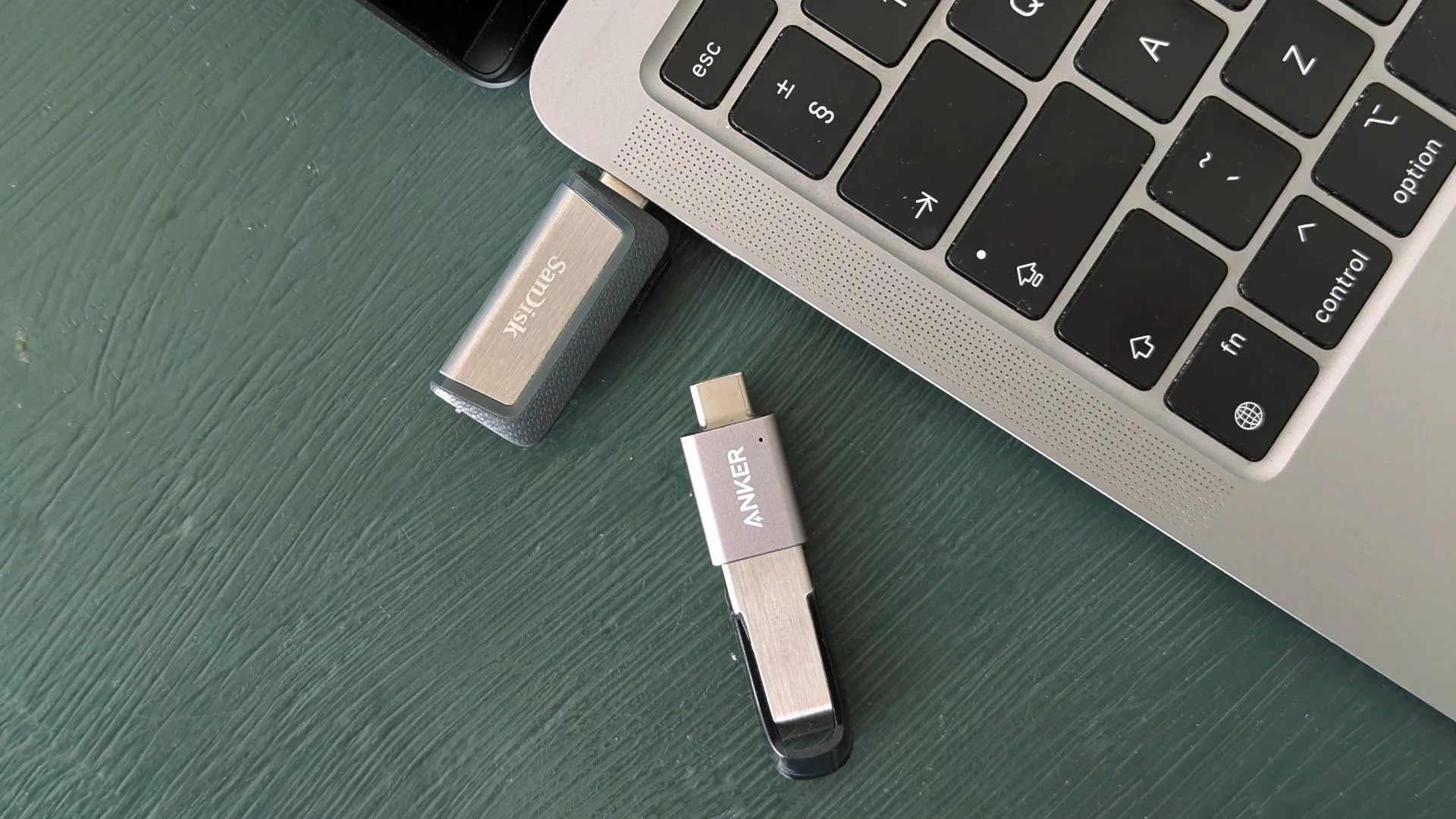 Các loại ổ USB flash drive đa dạng đặt cạnh MacBook, minh họa sự tiện lợi và phổ biến của thiết bị lưu trữ này.