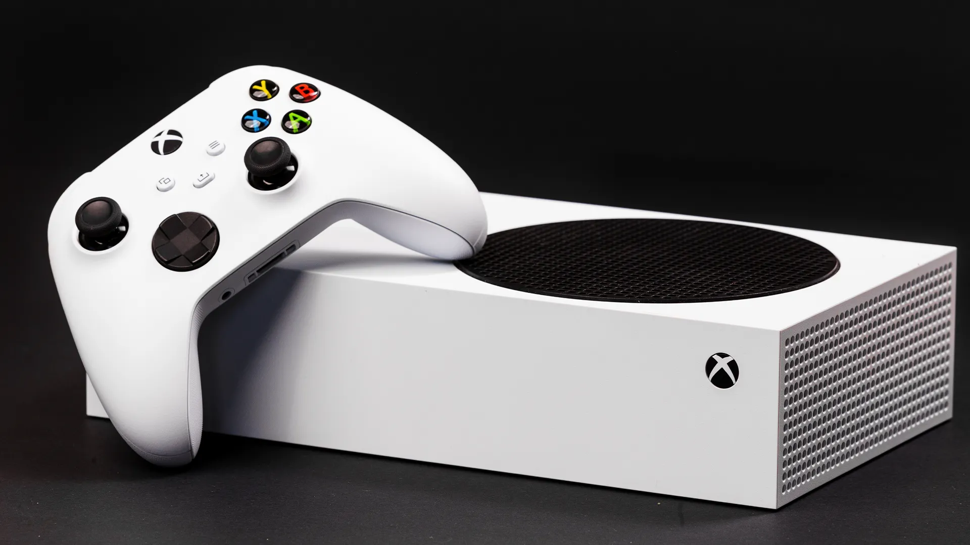 Chi tiết máy Xbox Series S đặt ngang cùng tay cầm điều khiển, biểu trưng cho sự đồng hành phát triển game đa nền tảng.