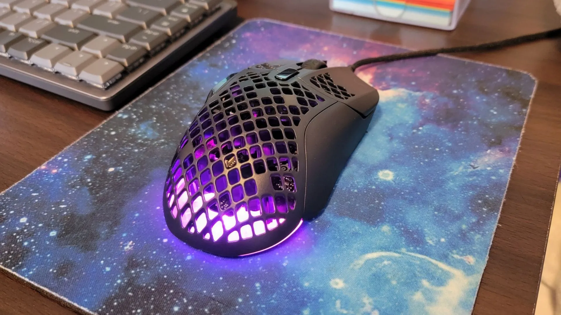 Chuột gaming SteelSeries Aerox 5 có dây trên thảm lót chuột galaxy