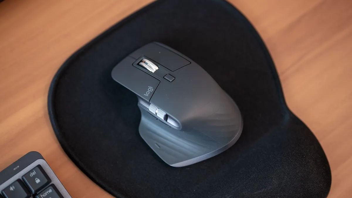 Chuột Logitech MX Master 3S đặt trên bàn di chuột, sẵn sàng thực hiện cử chỉ điều khiển âm lượng