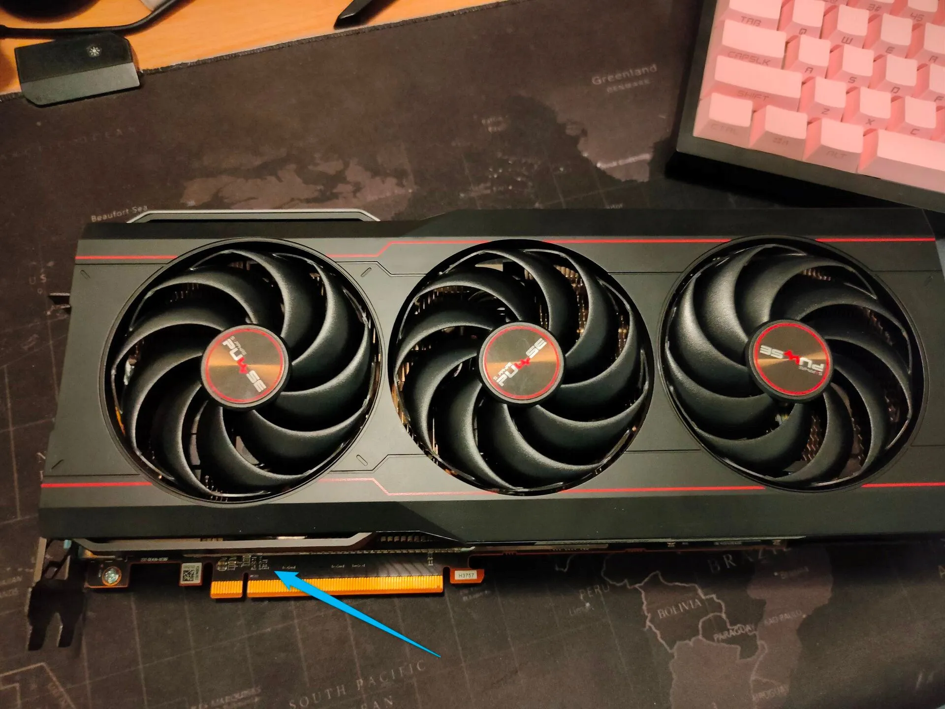 Hình ảnh cận cảnh card đồ họa Sapphire AMD RX 6800 XT đặt trên tấm lót chuột, hiển thị chi tiết các thành phần.