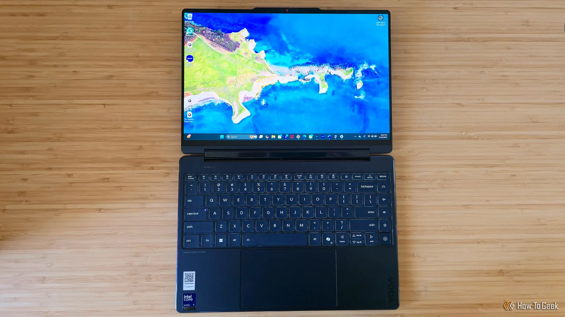 Laptop Lenovo Yoga 9i 2-in-1 Gen 10 Aura Edition nằm phẳng trên bàn làm việc