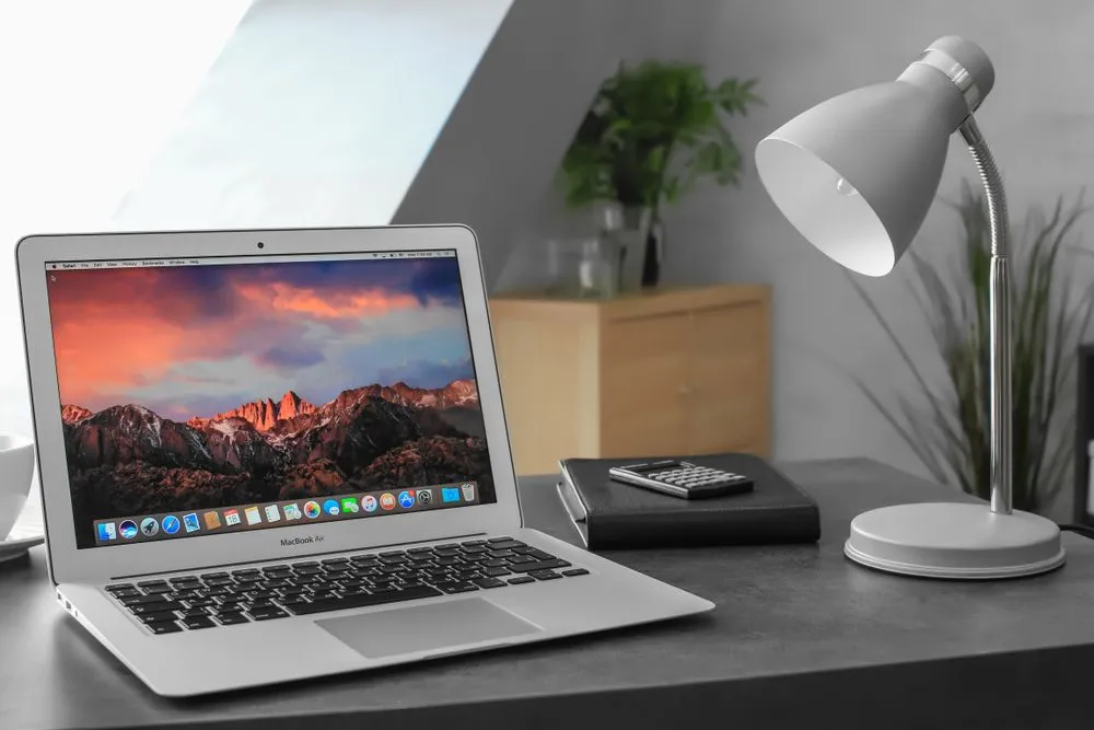 MacBook Air 2017 màu bạc đặt trên bàn với màn hình desktop