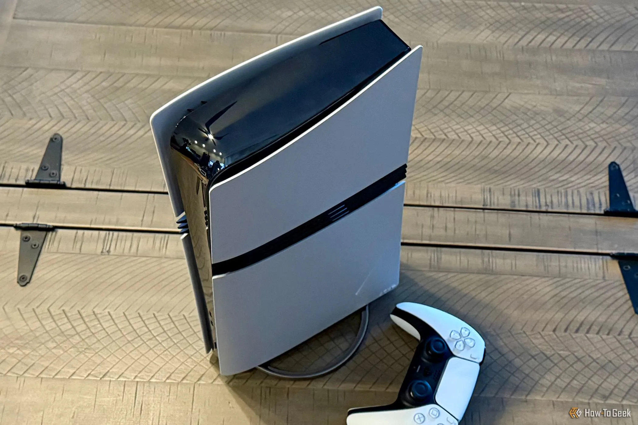 Máy PlayStation 5 Pro với ổ đĩa rời và tay cầm DualSense, đặt trên đế đứng.