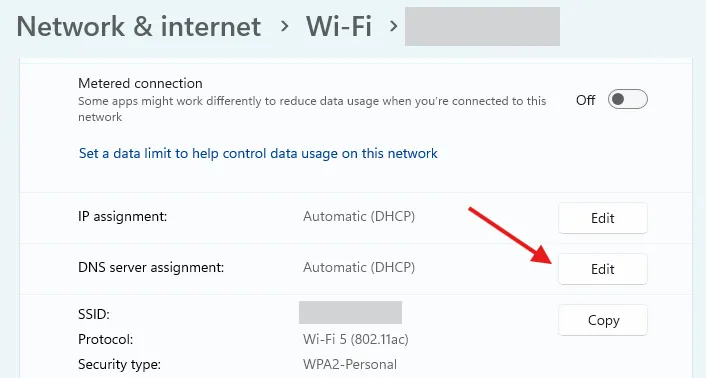 Menu cài đặt Wi-Fi trên Windows 11, mũi tên đỏ chỉ vào nút &quot;Edit&quot; (Chỉnh sửa) cho phần &quot;DNS Server Assignment&quot; để thay đổi DNS.