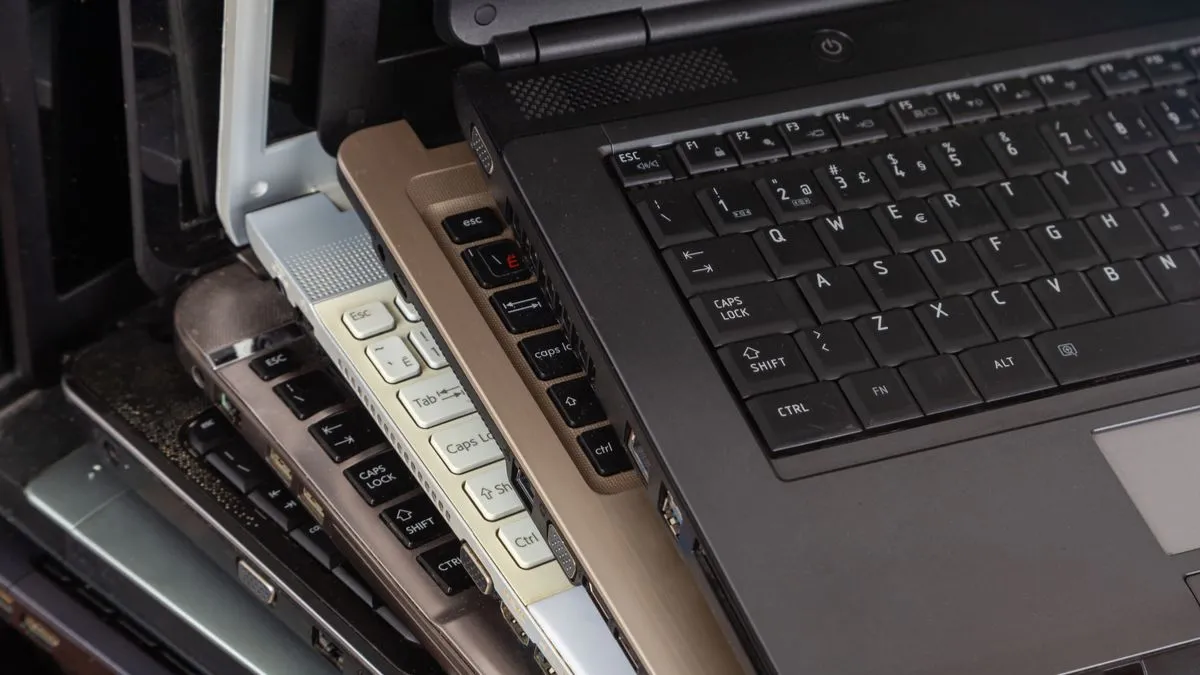 Một chồng laptop cũ bụi bặm.