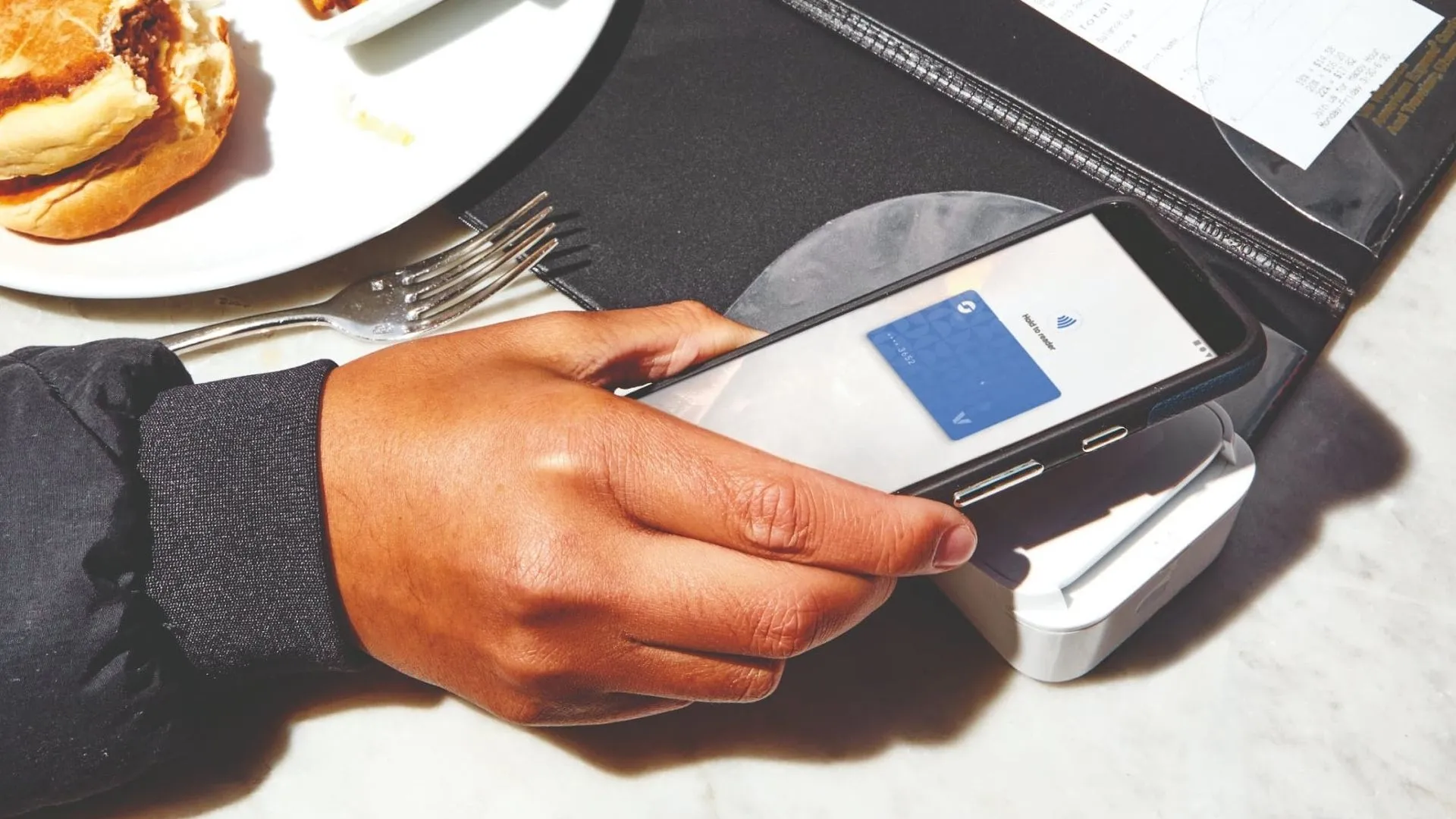 Một khách hàng đang thanh toán bằng Google Wallet tại máy POS không tiếp xúc