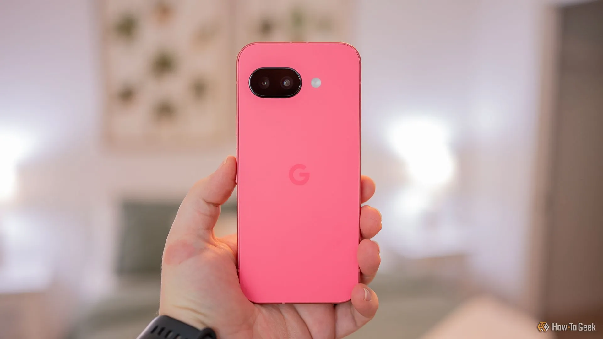 Người đang cầm điện thoại Google Pixel 9a cho thấy mặt lưng của điện thoại.