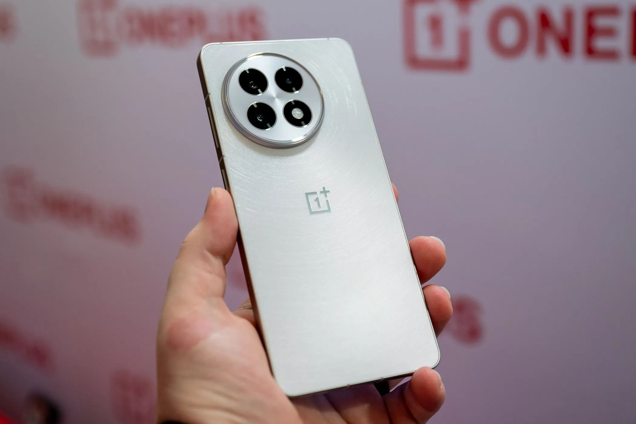 Người dùng cầm OnePlus 13R màu trắng, minh họa thiết kế sang trọng và dung lượng pin lớn, sạc nhanh.