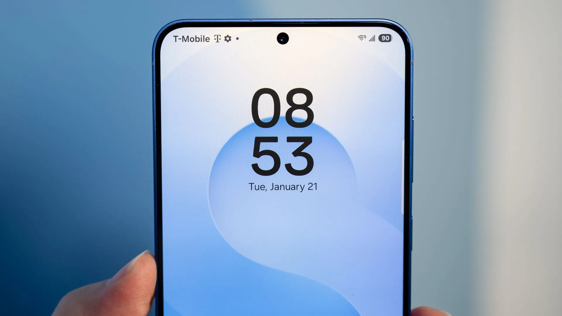 Người dùng cầm Samsung Galaxy S25, nhìn vào camera trước và viền màn hình, liên quan đến trải nghiệm sử dụng pin