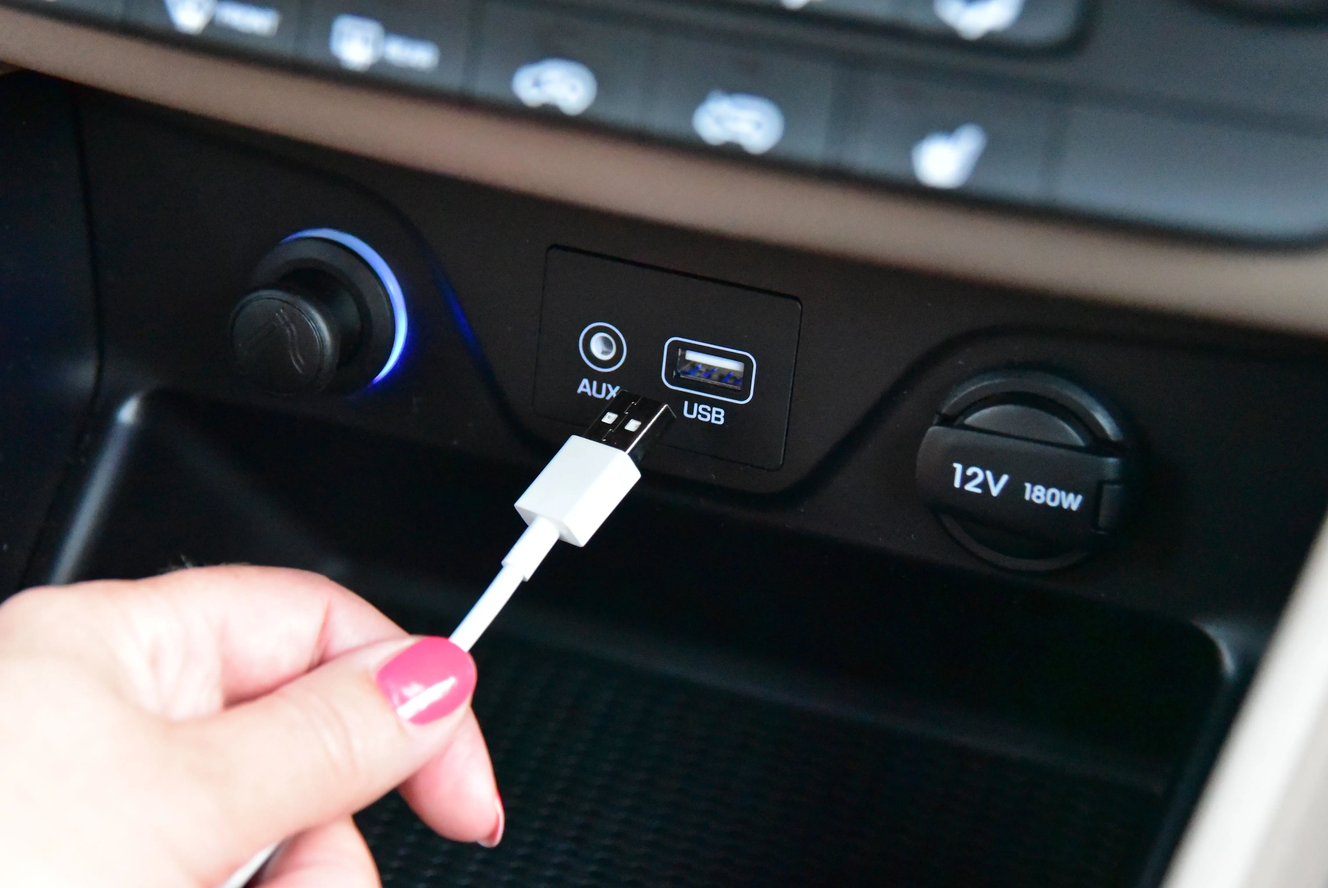 Tay cắm cáp USB-A vào cổng trên xe ô tô, biểu tượng cho việc phải thử nhiều lần để cắm đúng chiều