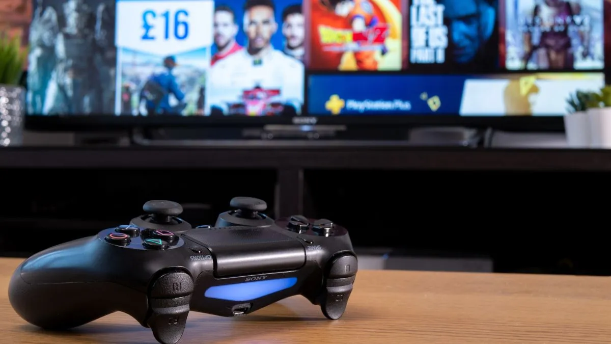 Tay cầm Sony Dualshock 4 đặt trước màn hình TV hiển thị giao diện PlayStation Store, minh họa việc mua game kỹ thuật số và bị giới hạn giá.