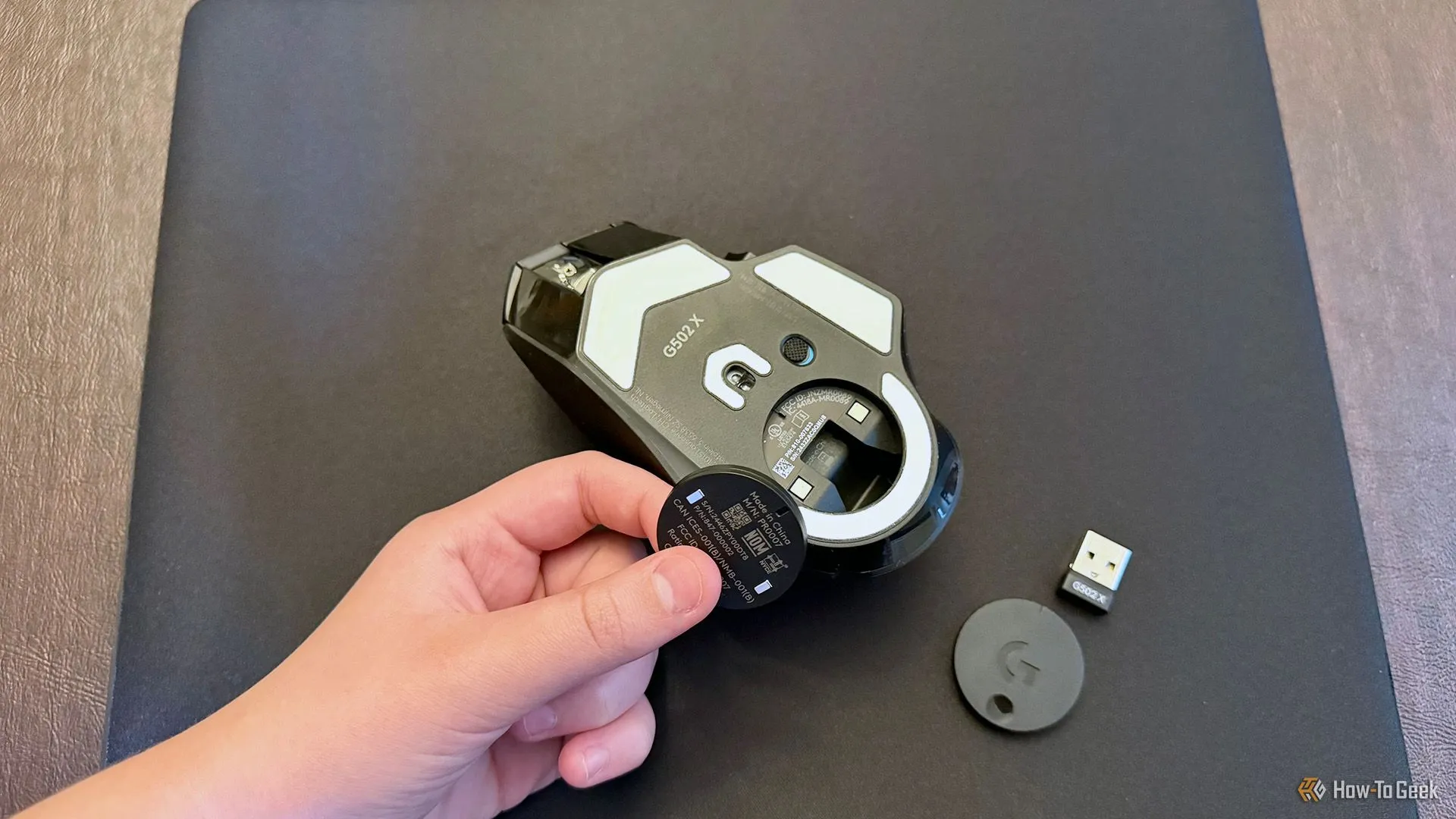 Thao tác lắp đồng xu Powerplay 2 vào khoang pin của chuột Logitech G502 X Plus Lightspeed