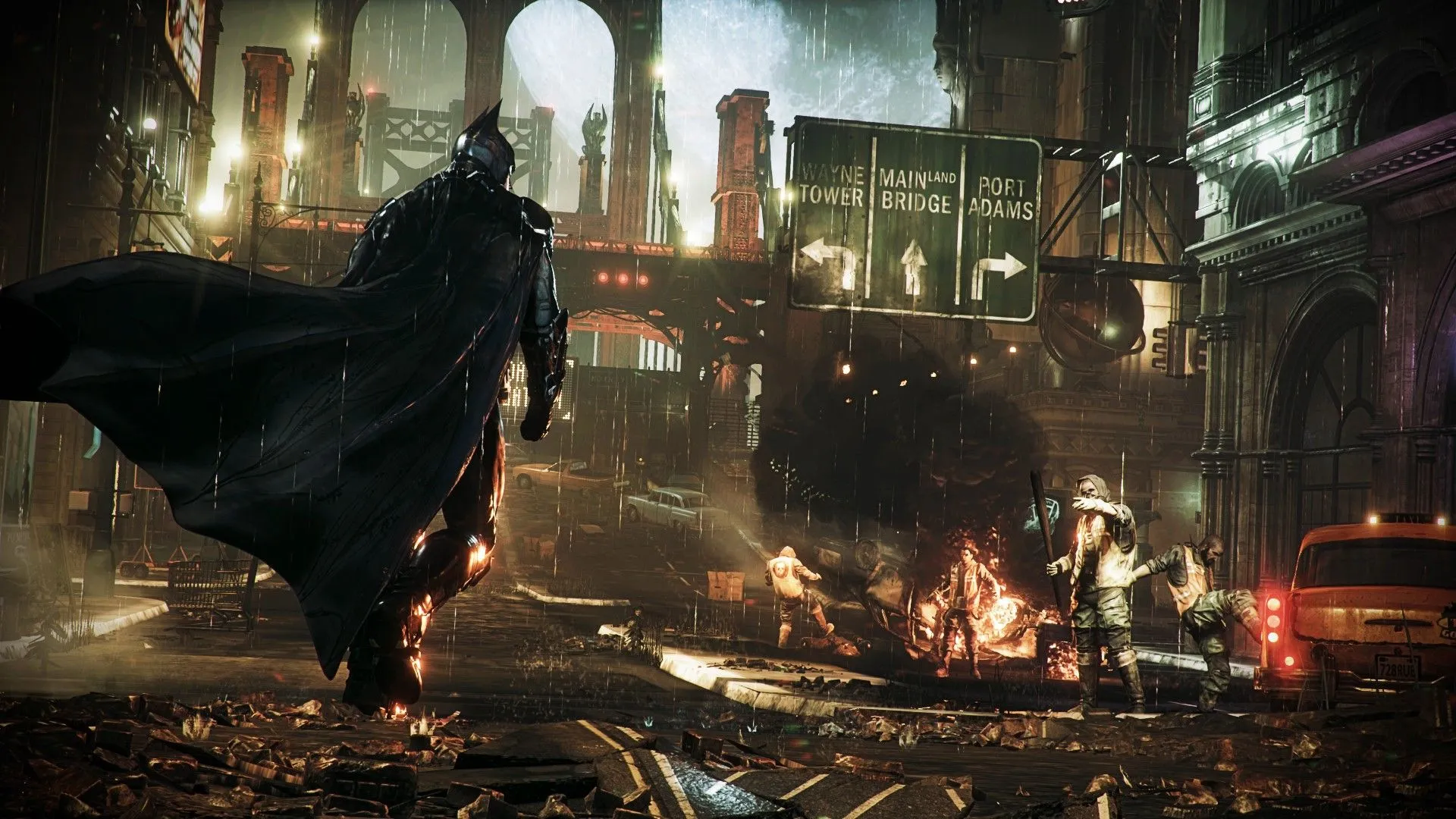 Batman đi về phía bọn tội phạm đang phá hủy thiết bị trong Batman Arkham Knight