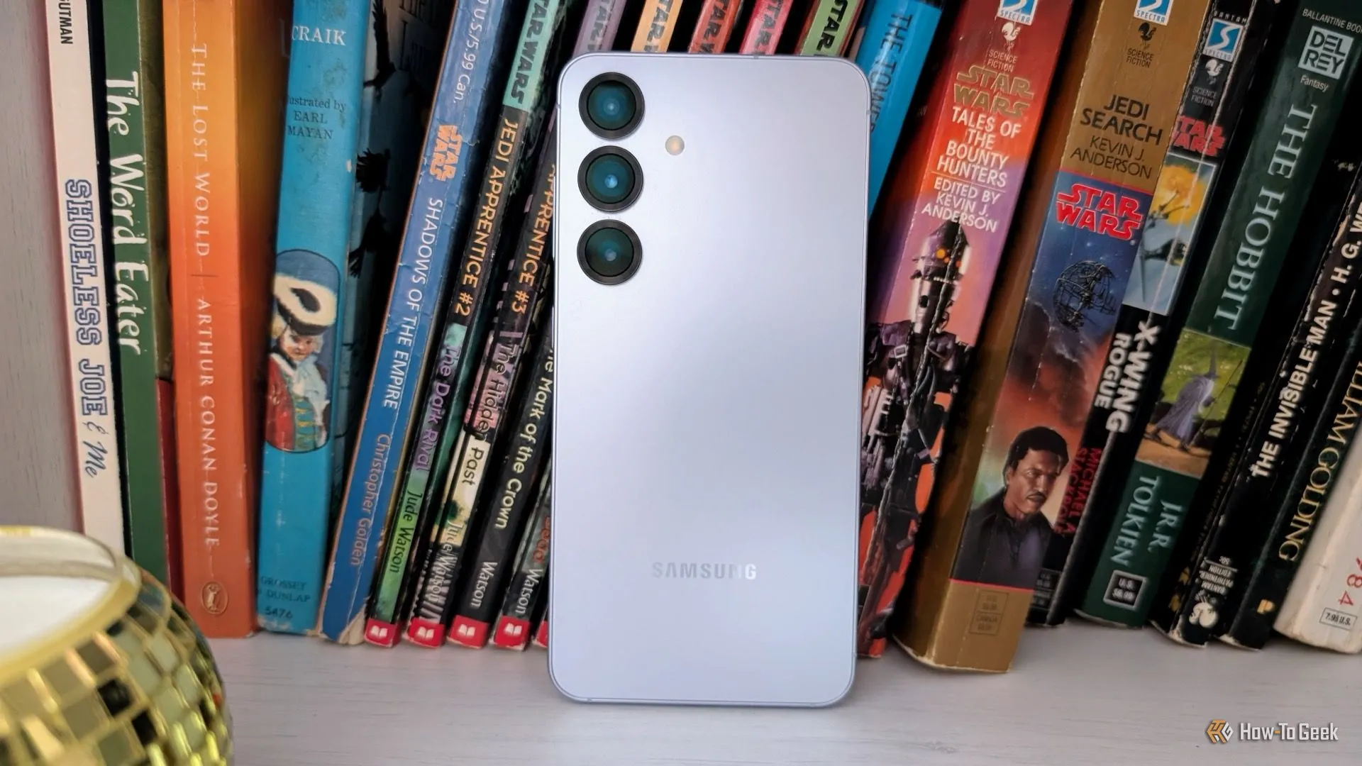 Điện thoại Samsung Galaxy S25 màu xanh bạc đặt trên kệ