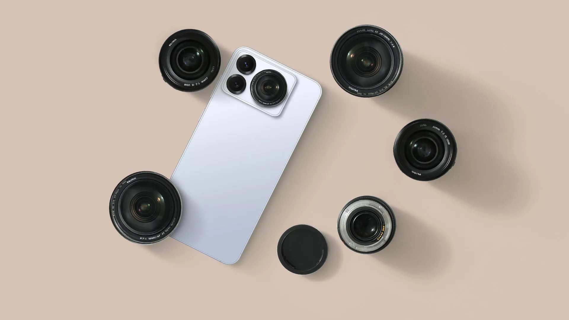Một chiếc smartphone màu đen đặt cạnh một số ống kính máy ảnh rời.
