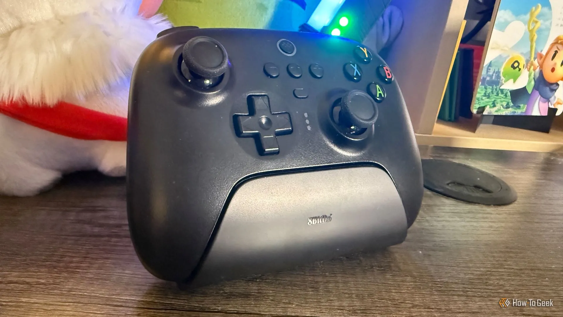 Tay cầm chơi game 8BitDo Ultimate 2.4G đặt trên dock sạc đi kèm, hiển thị góc nhìn từ bên