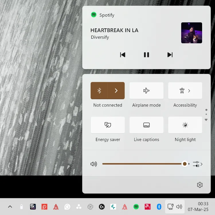 Ảnh chụp màn hình Trung tâm Hành động (Action Center) của Windows 11, cho thấy trình điều khiển media khi Spotify đang phát, minh họa sự thiếu phản hồi trực quan.