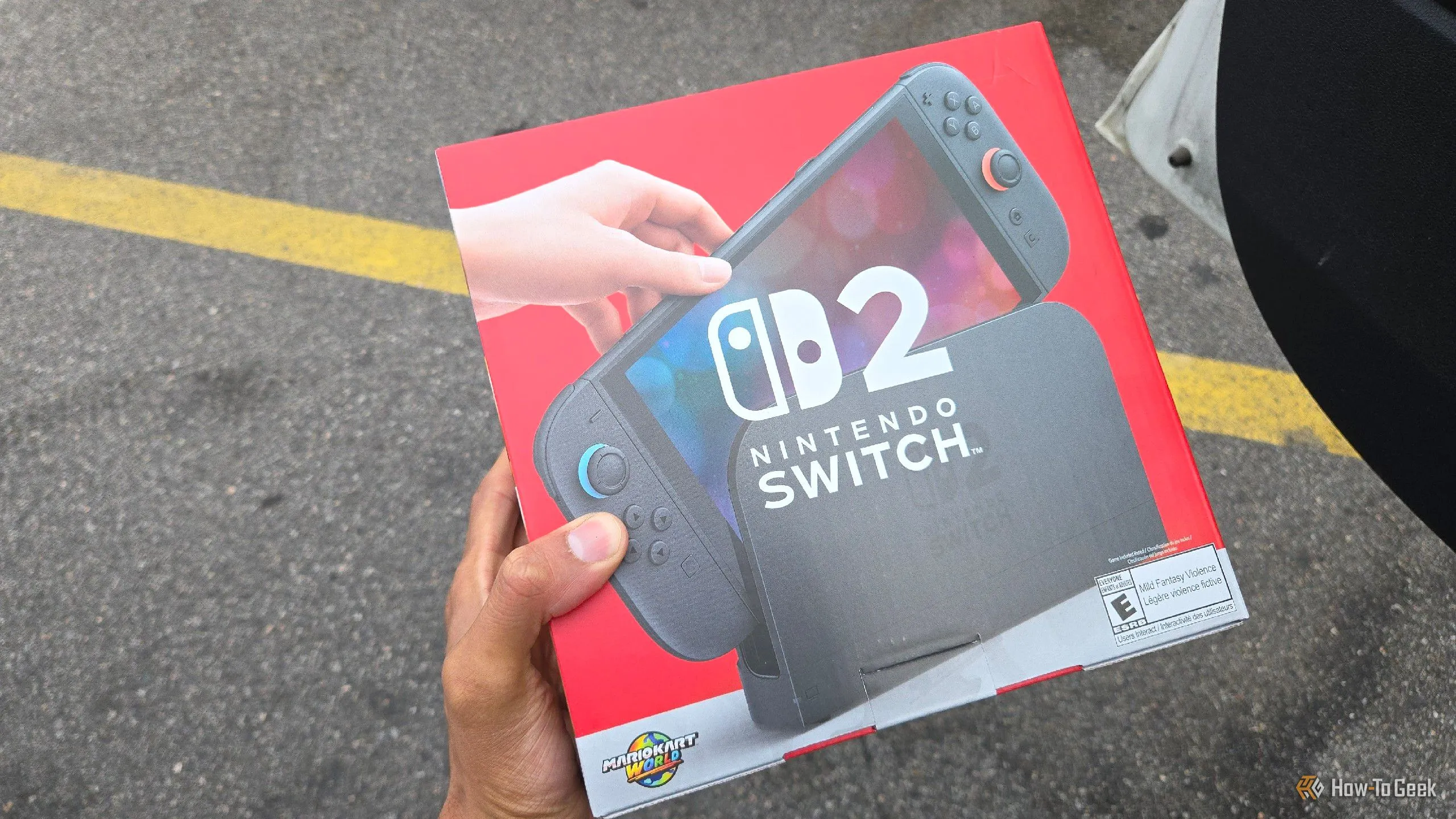 Cận cảnh một bàn tay đang cầm hộp Nintendo Switch 2, minh họa hành động sở hữu thiết bị