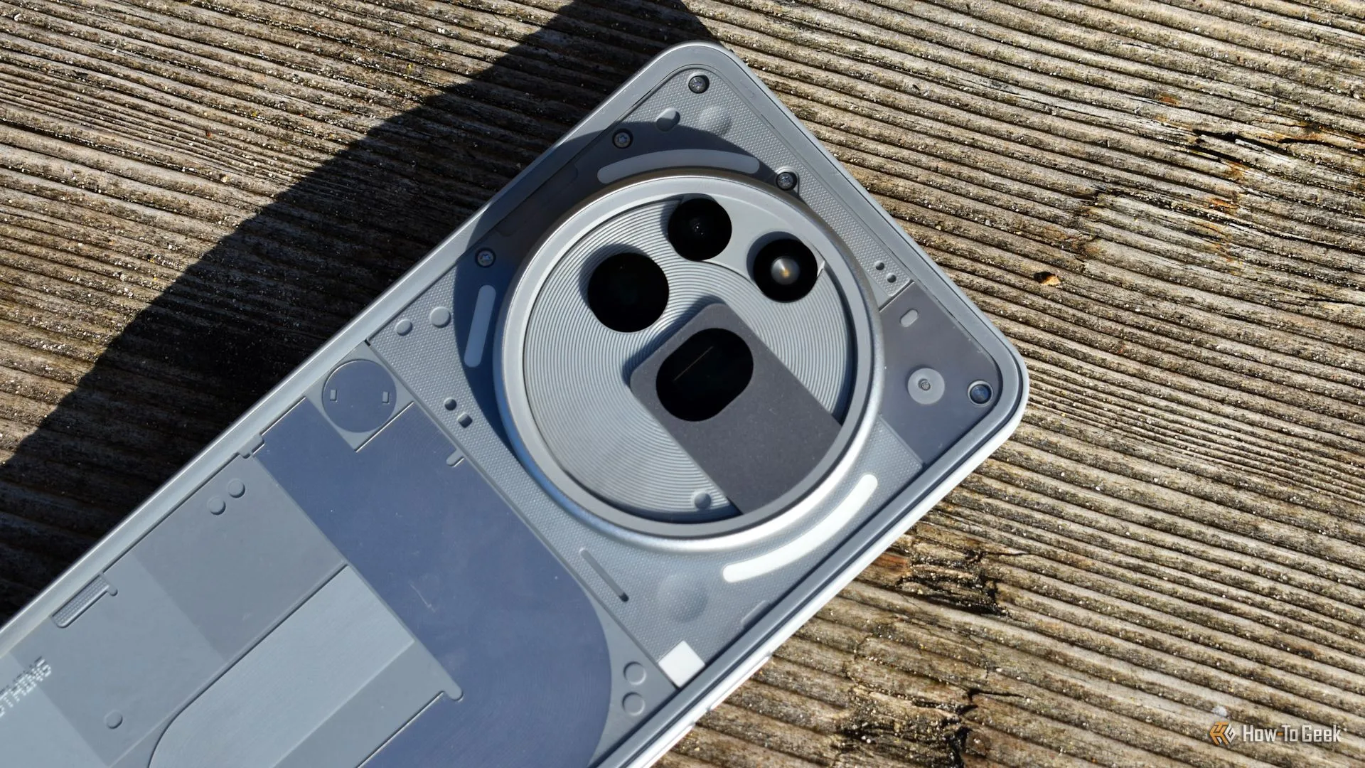 Cụm camera ba ống kính của Nothing Phone (3a) Pro nhìn từ trên xuống, mặt lưng màu xám độc đáo.