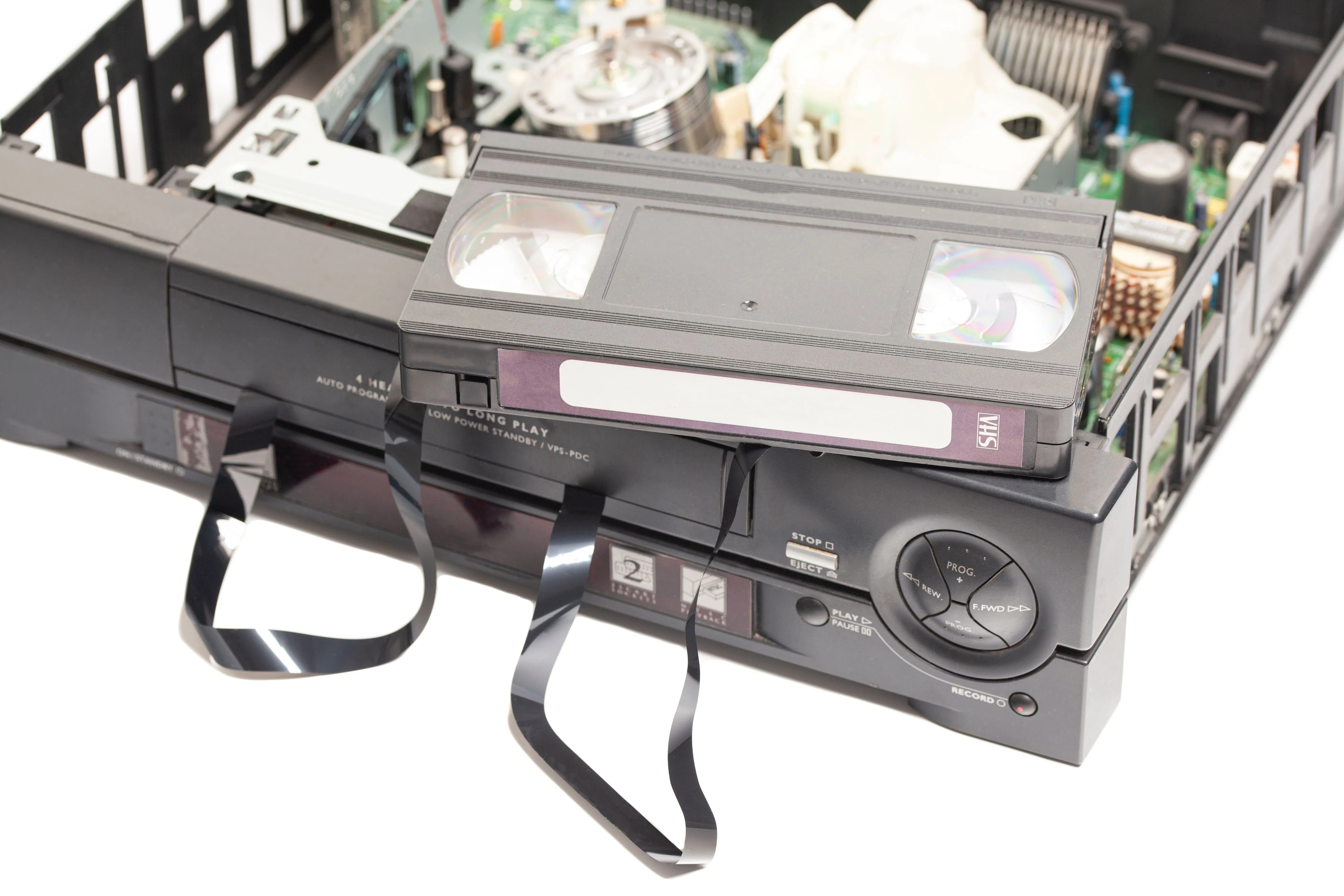 Đầu VCR và băng VHS bị hỏng, băng từ bị xổ ra, tượng trưng cho những kỷ niệm về công nghệ giải trí gia đình analog.