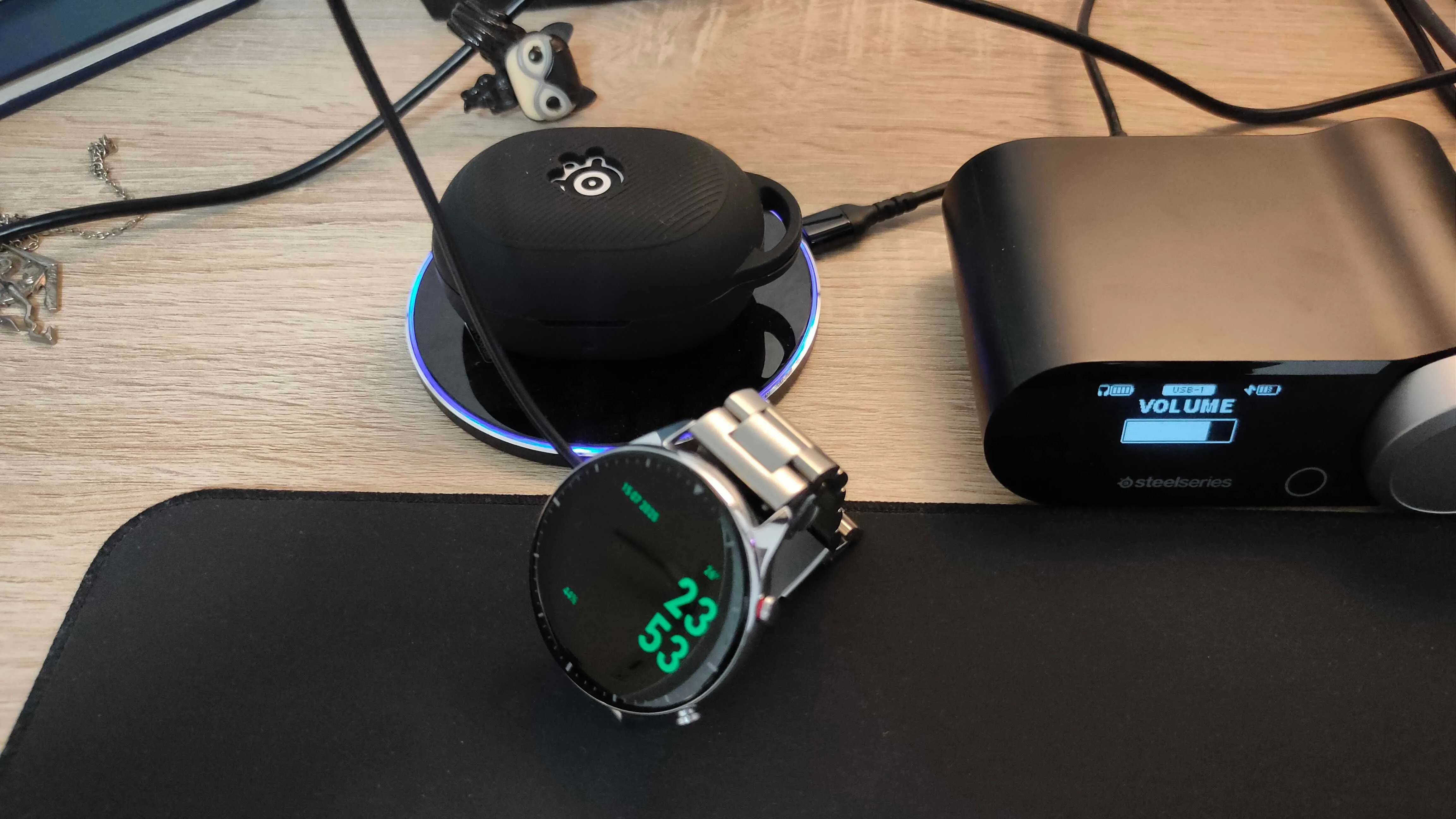 Đồng hồ thông minh Amazfit GTR 2 và tai nghe SteelSeries Arctis GameBuds đang sạc, tận dụng cổng USB của màn hình