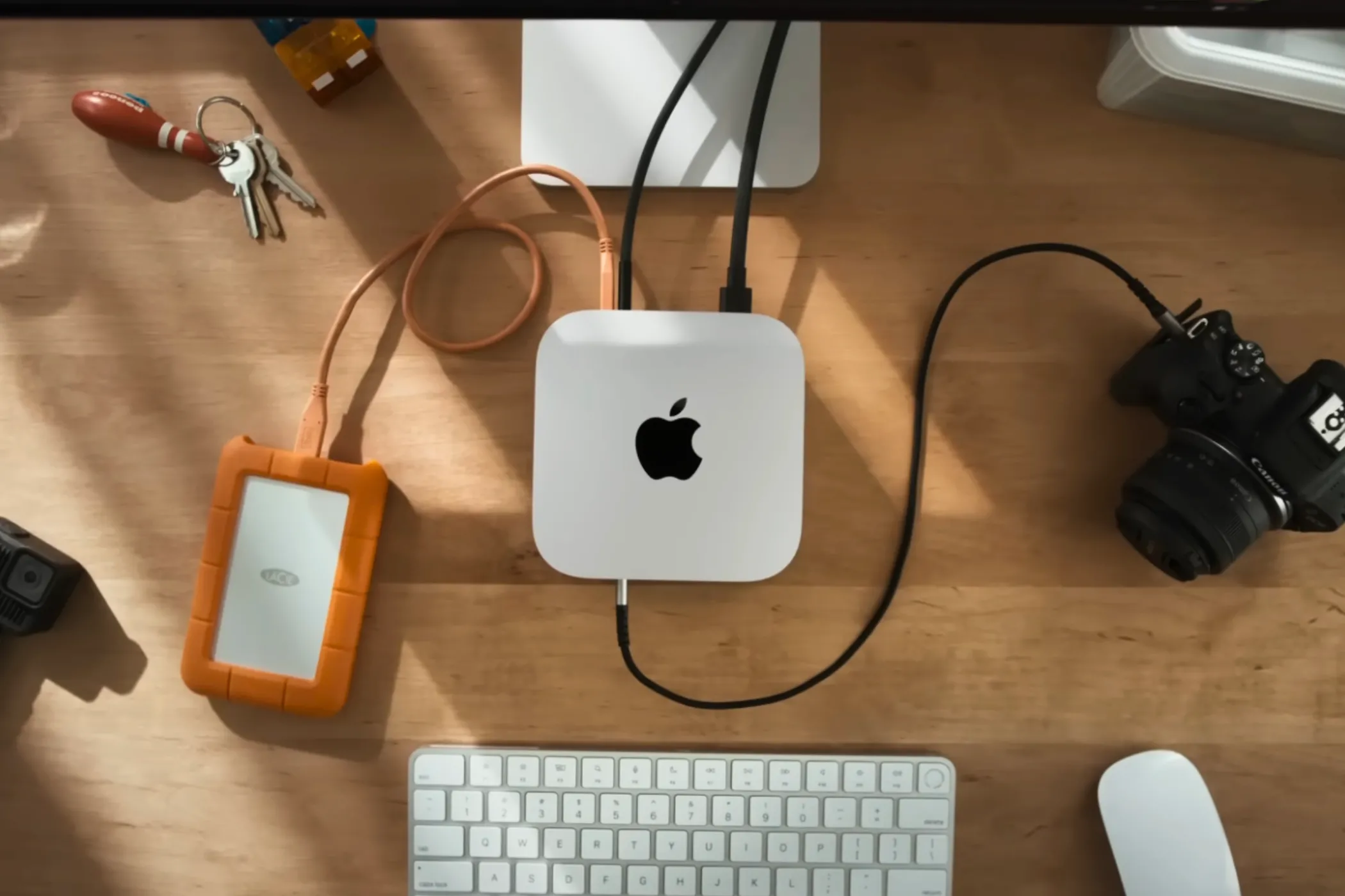 Góc nhìn từ trên xuống của Mac mini M4 trên bàn làm việc với các phụ kiện xung quanh.