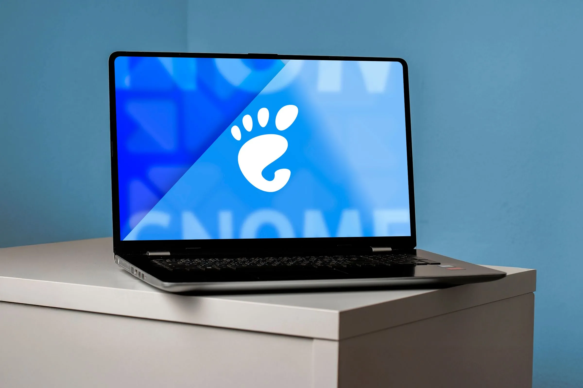 Màn hình laptop hiển thị logo GNOME, thể hiện trải nghiệm người dùng tập trung vào không gian làm việc ảo.