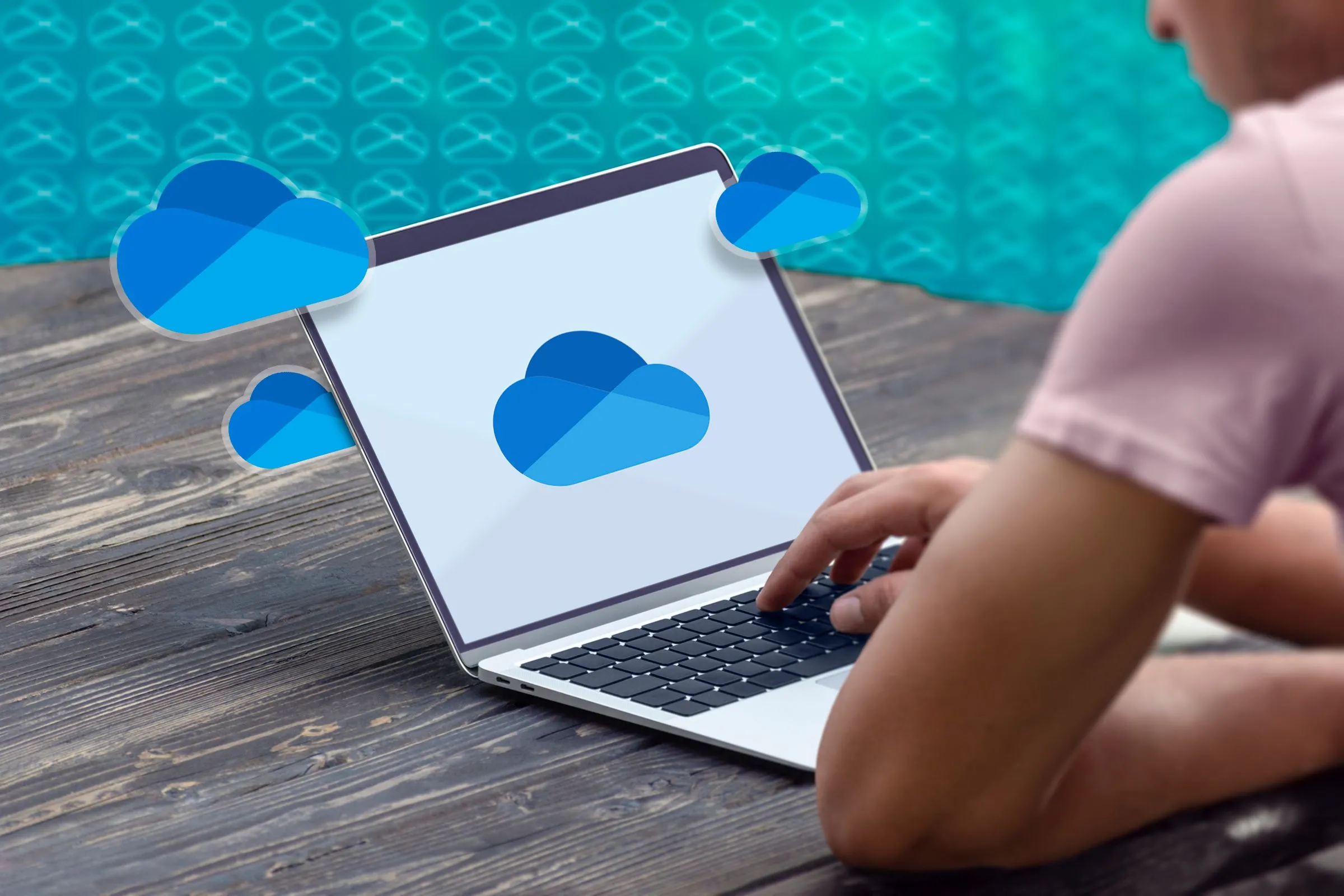 Một người đang sử dụng laptop với logo OneDrive trên màn hình